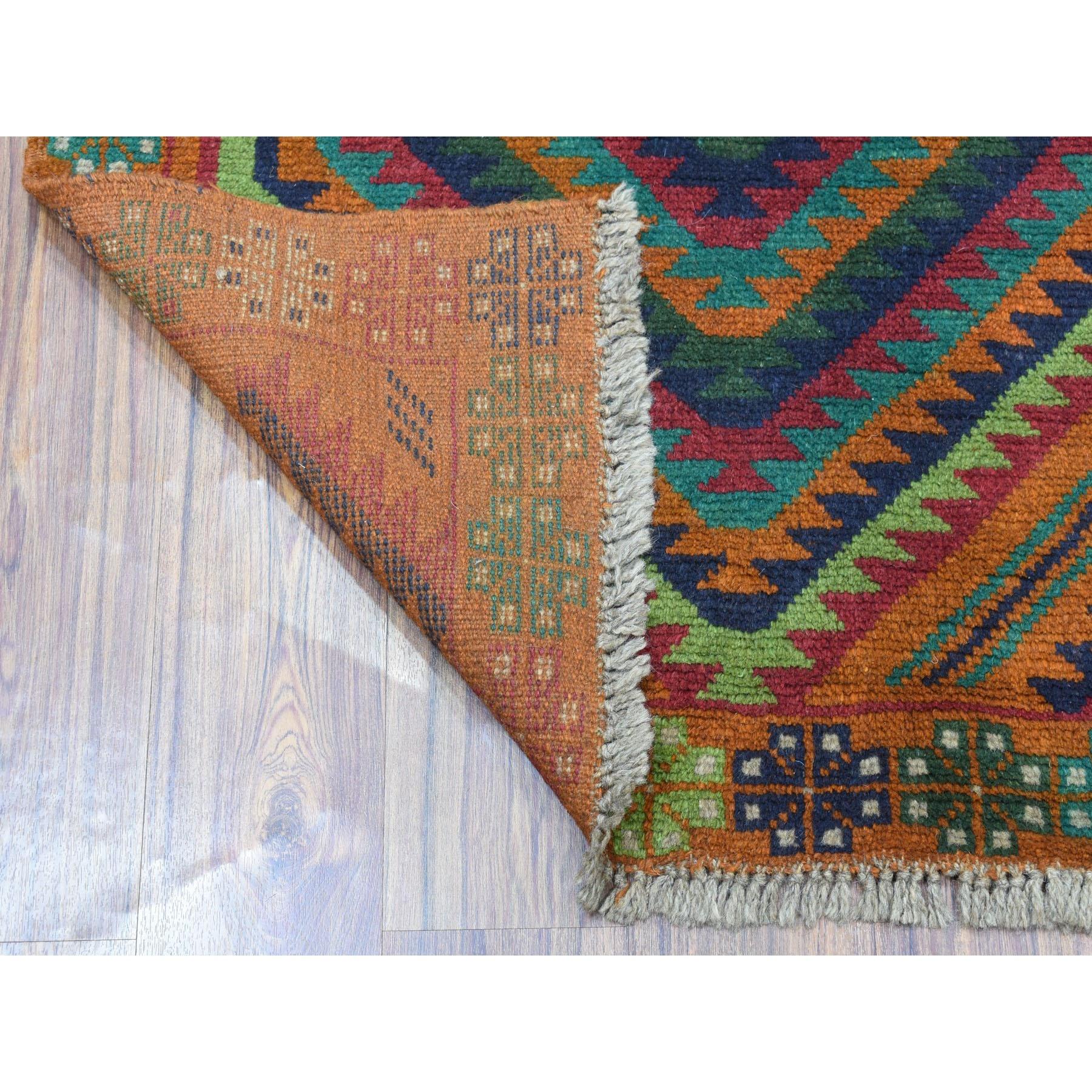 Il s'agit d'un véritable tapis d'Orient en laine pure, noué à la main, aux couleurs de l'orange brûlé, de l'Afghan Baluch et au design géométrique. Il a été tissé pendant des mois et des mois selon les techniques séculaires de l'artisanat persan par