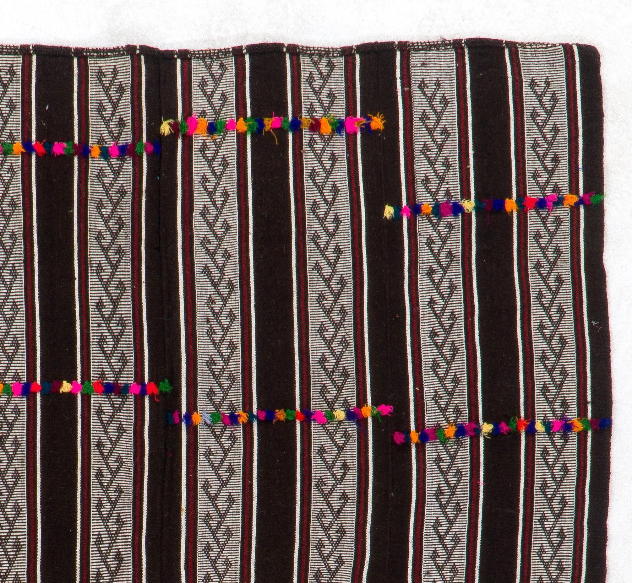 This vintage banded Turkish kilim has a simple elegance with its large stripes in the natural, earthy tones of cream and brown of goat's wool and sheep's wool that it is made of, as well as gorgeous burgundy. The delicate hook motifs all over the