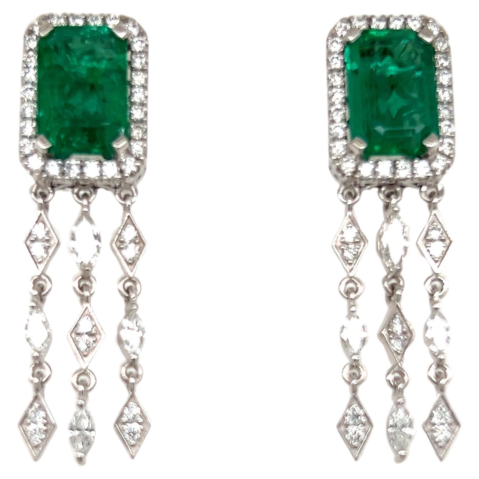 Glamorous dangling emerald earrings. High brilliance with rich grass green tone two matching 5.92 carat emerald cut natural emeralds encased in basket mounting with four bead prongs, accented with round brilliant cut diamonds. Handcrafted dangling