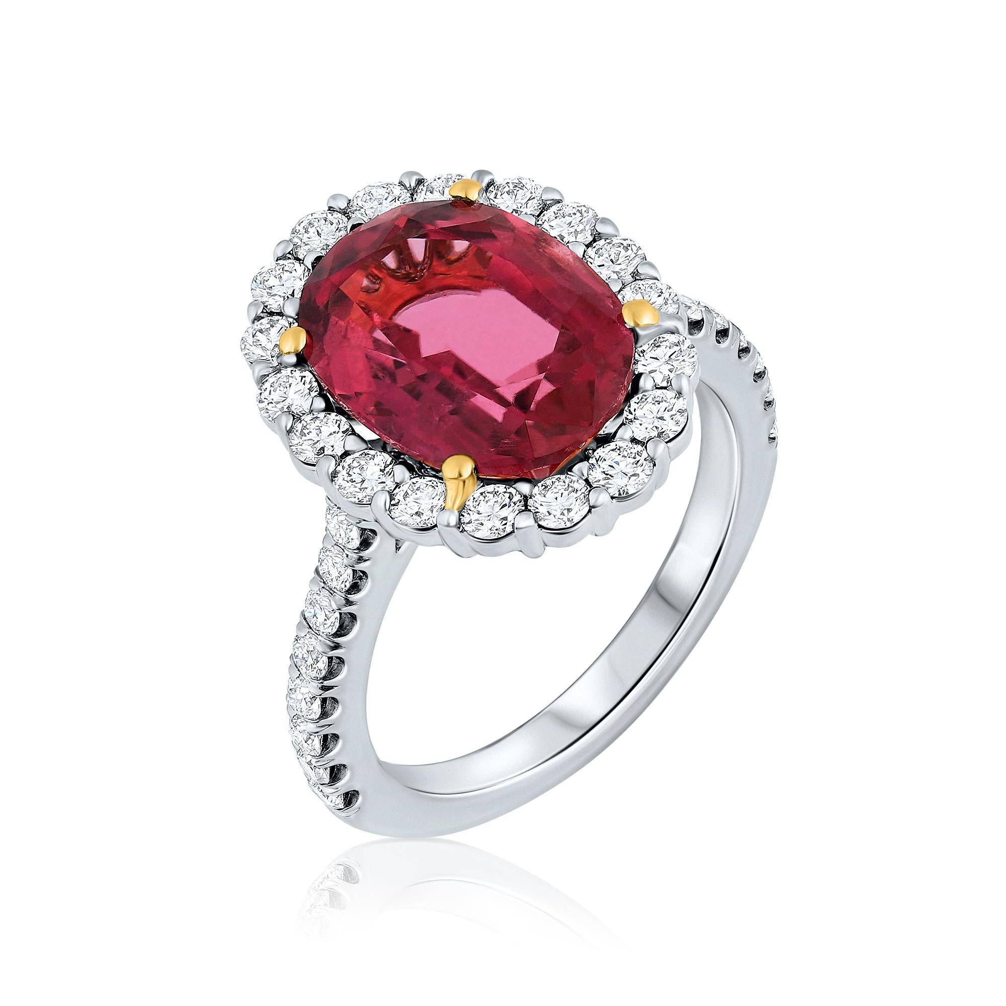 A stunning cocktail ring featuring a 4.93-carat oval-shaped Red Tourmaline (Rubellite) as its breathtaking centerpiece. Surrounding the vibrant center stone are sparkling round brilliant Diamonds, creating a halo effect that enhances its beauty.