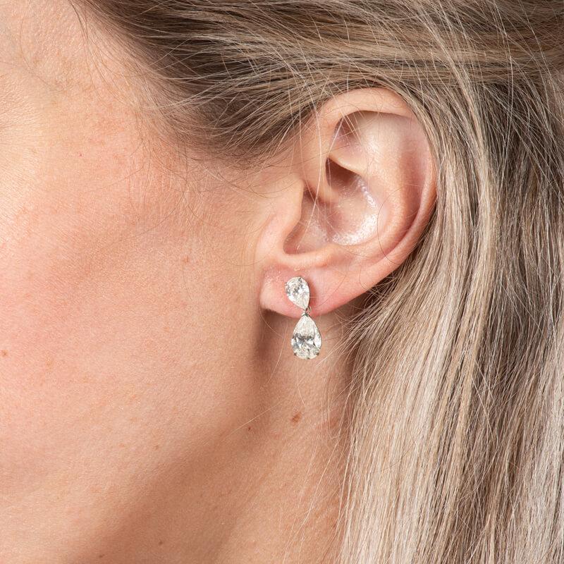 Ces magnifiques boucles d'oreilles à couper le souffle sont composées de diamants en forme de poire d'un poids total de 5,93ct, sertis dans une monture basse en or blanc 14 carats. Poteau à friction avec dos papillon jumbo. 
Mesures : Longueur