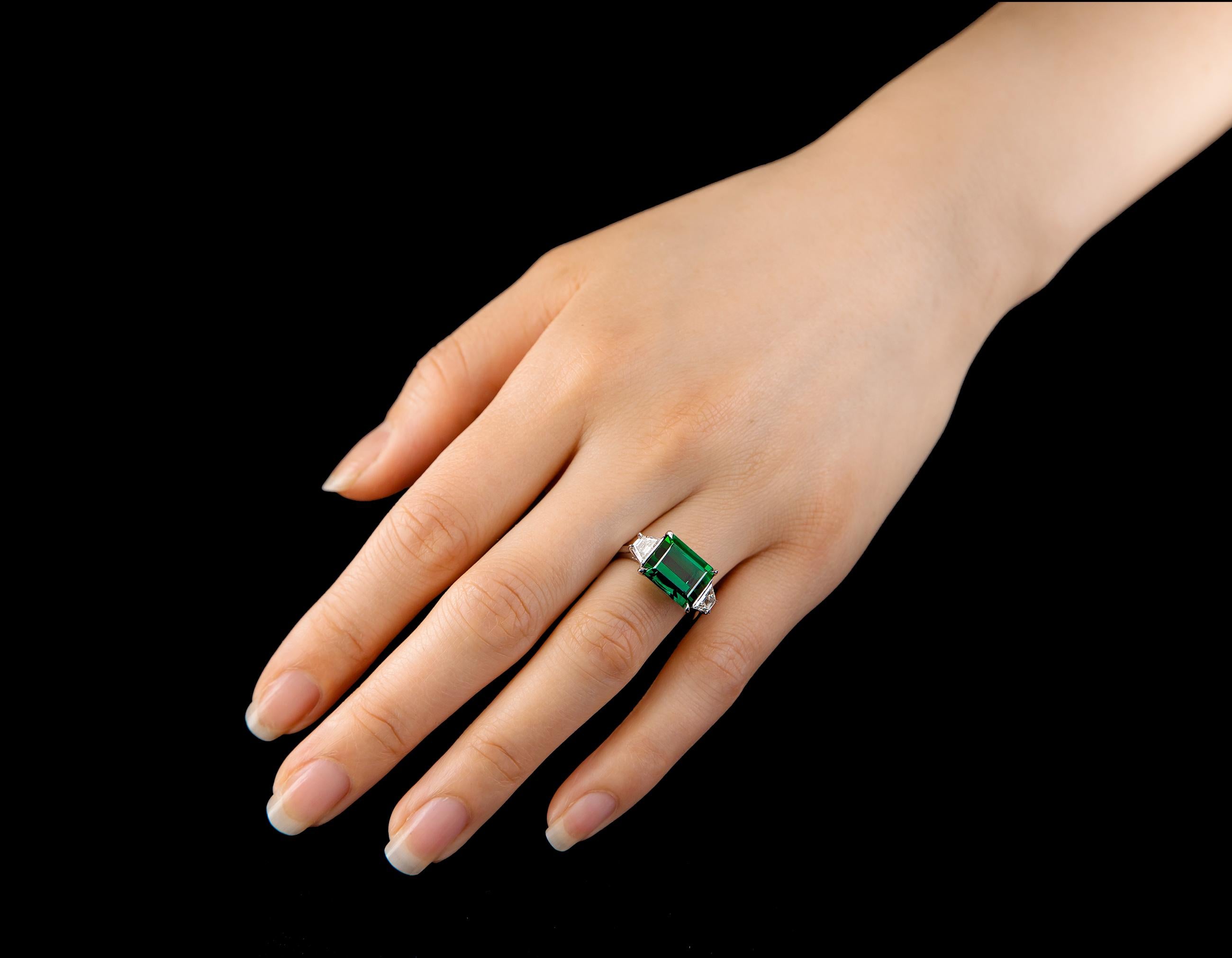 A classic three-stone ring featuring a 5.95 ct emerald cut tourmaline and trapezoid diamonds.

Finger size: US - 5 3/4 
Chrome tourmaline - 5.95 carat
Trapezoid diamonds -  0.79 carats total
Single claw prongs
