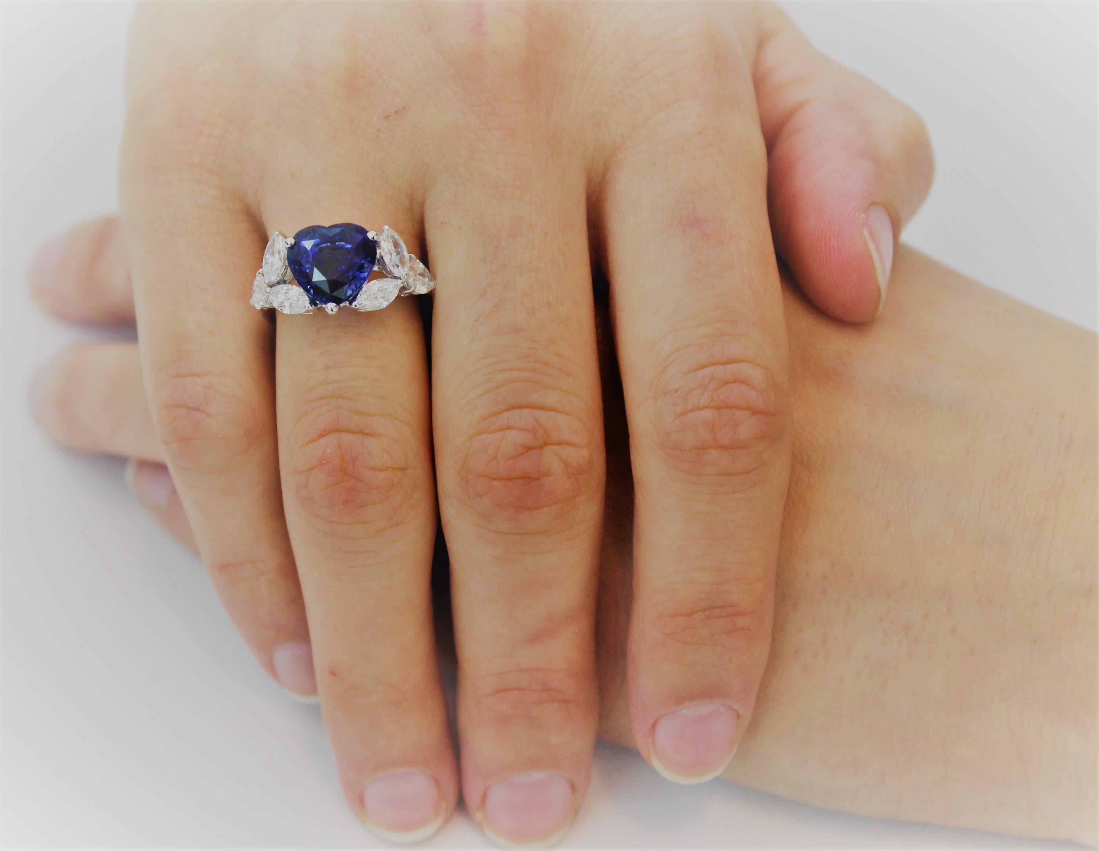 Romantic Hand-Made Cocktail Ring featuring a 5.95 Carat Blue Heart Shape Sapphire embraced by 6 White Marquise Diamonds for 1.63 Carat total.