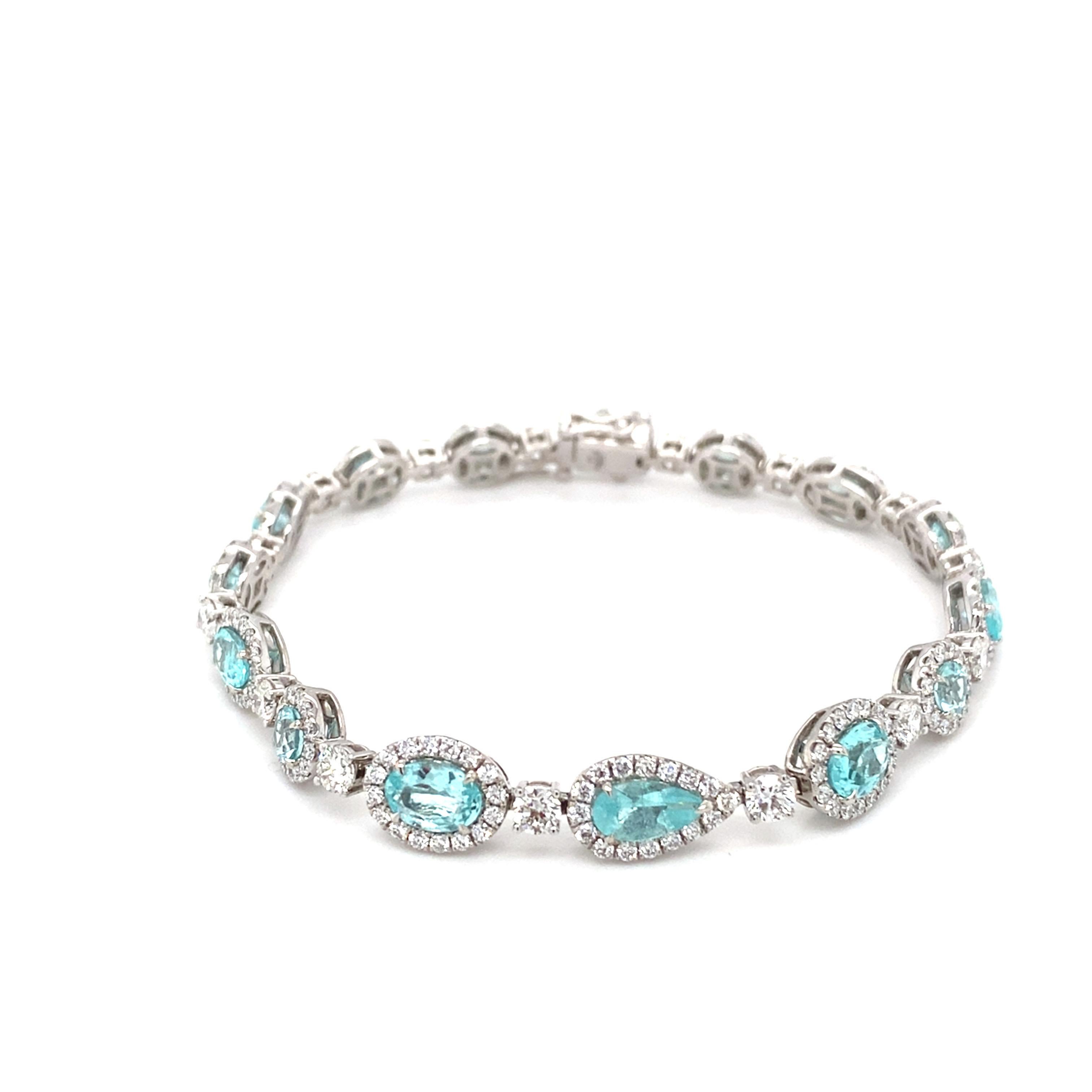 This exquisite 5.95-carat Paraiba tourmaline diamond bracelet features multi-cut tourmalines surrounded by a halo of diamonds, each linked with a solitaire diamond. With 15 stations in total, the bracelet is designed for secure wear with a double