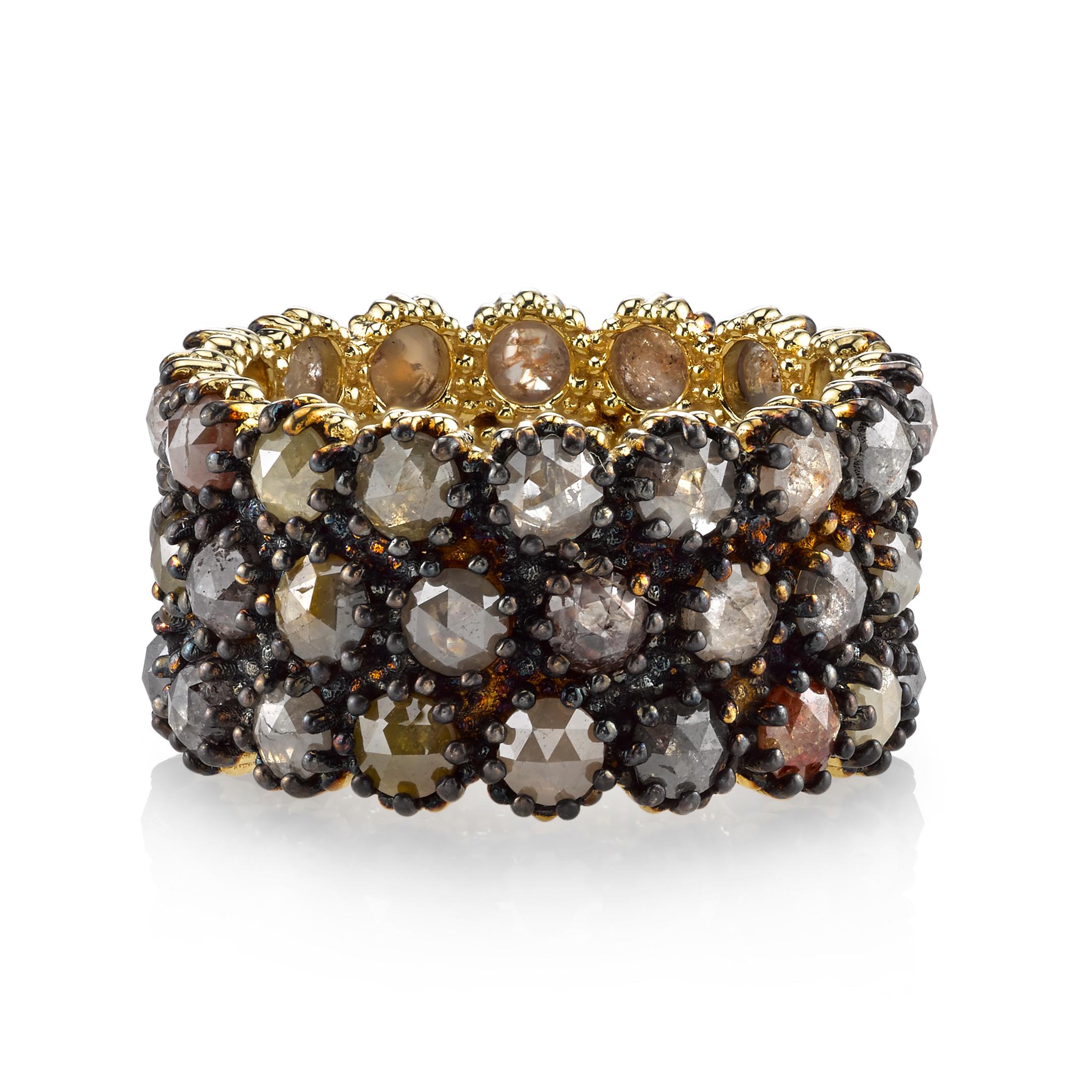 This 18 Karat Yellow Gold band is perfect for a woman on the cutting edge of style that isn't afraid to make a bold statement. The Black Rhodium finish perfectly complements the muted, Earth tones of the Rustic Diamonds that elegantly wrap around