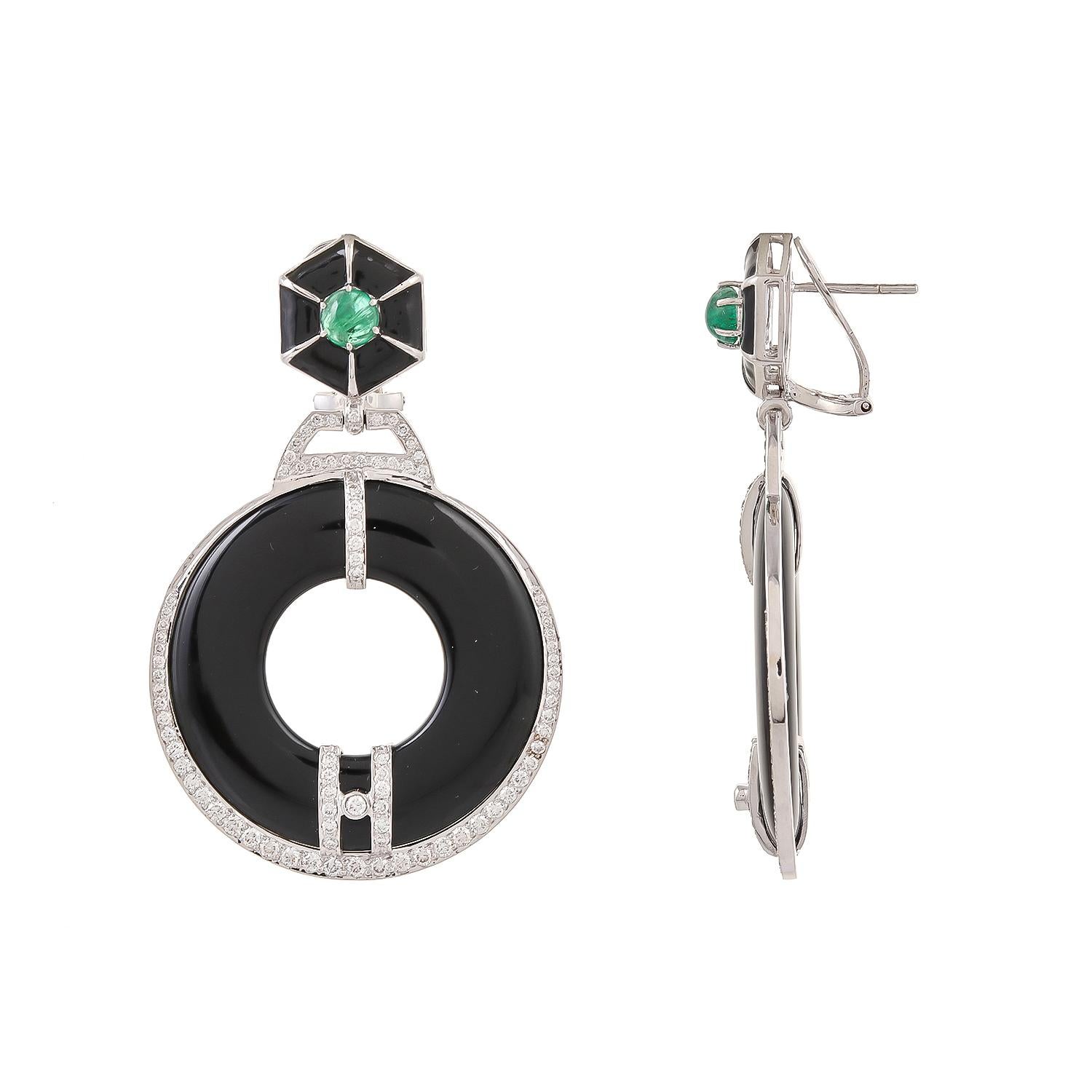 A captivating 18 karats white gold earring boldly features glossy black onyx weighing 59.55 carats approximately, is accented by brilliant 2.14 carats round diamonds. The studded emerald weighing 1.38 carats approximately is coupled with black