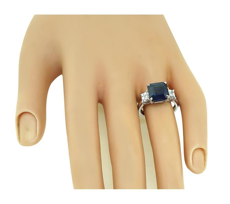 Questo è uno splendido anello di fidanzamento in platino. L'anello è centrato da un delizioso zaffiro di Ceylon taglio smeraldo che pesa circa 5.95 carati. La pietra centrale è accentuata da scintillanti diamanti taglio smeraldo certificati GIA del