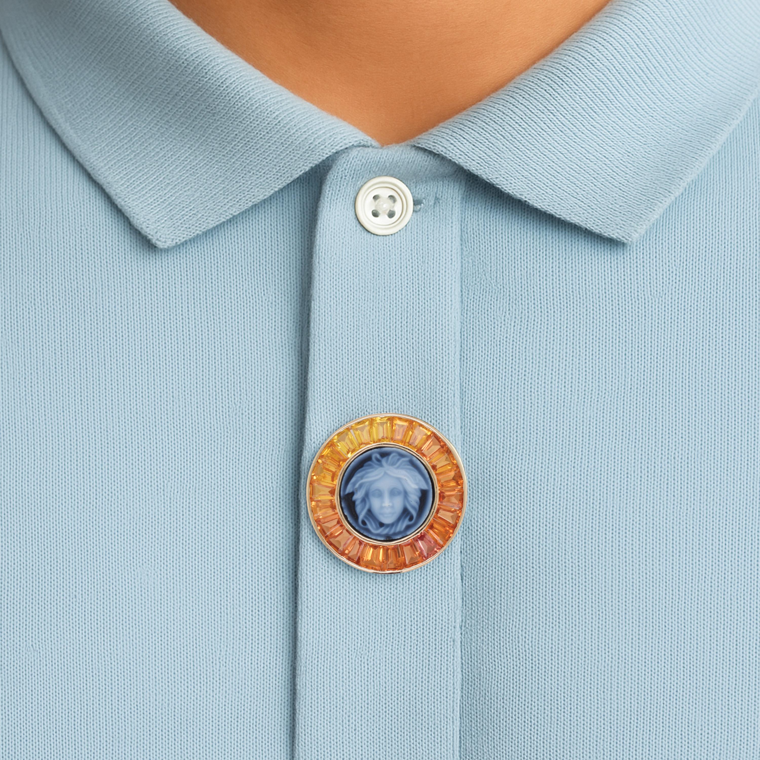 Command attention with this bold and artistic 5.96 Carat Yellow Sapphire Baguette Cut Medusa Versace Cameo Brooch, a true masterpiece that merges ancient symbolism with contemporary luxury.
At the heart of the brooch lies a meticulously carved