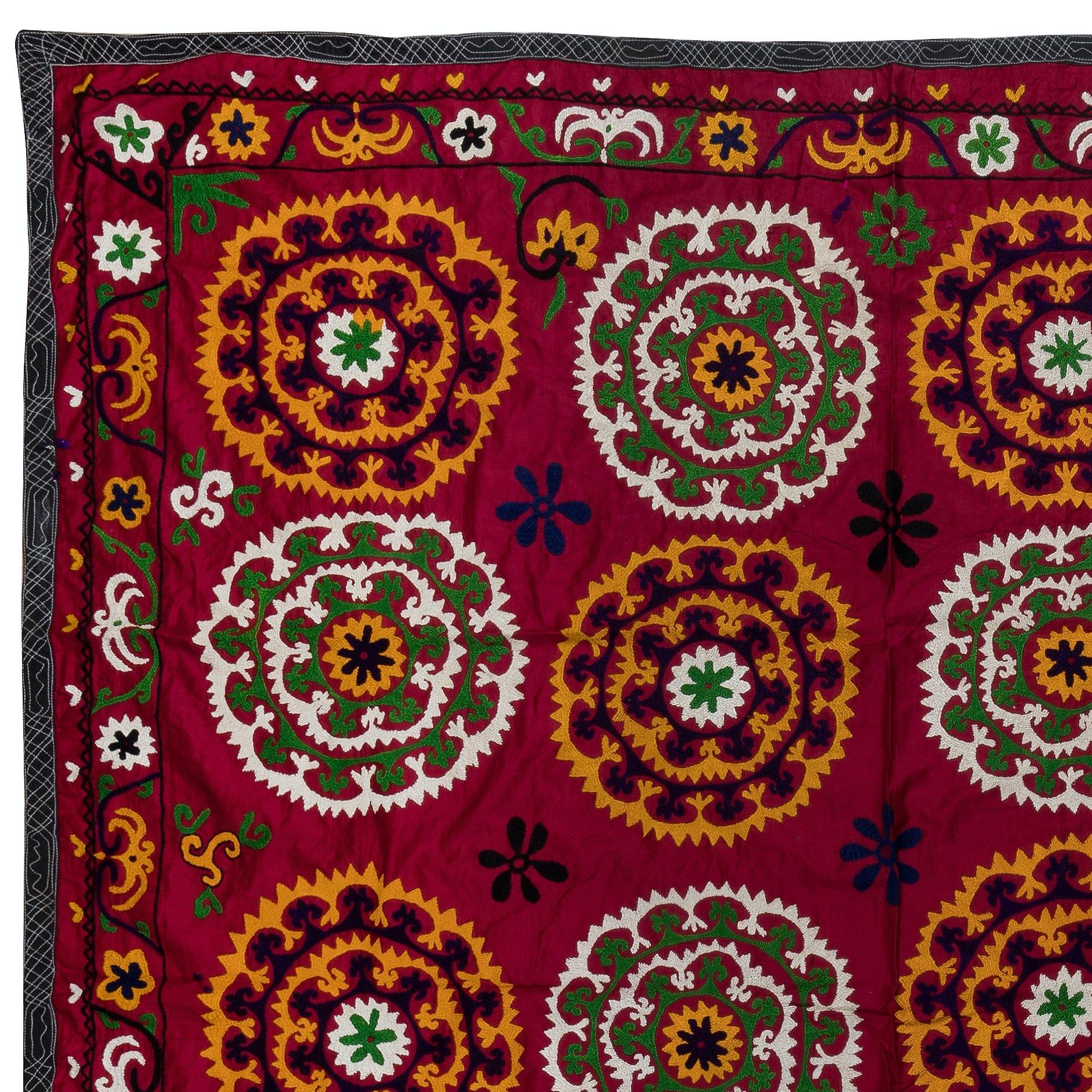Tauchen Sie ein in die Welt der leuchtenden Farben und der aufwendigen Handwerkskunst mit unserem usbekischen Suzani Wandbehang oder Bettbezug aus handgestickter Seide. Dieses atemberaubende Stück ist perfekt, um Ihrer Einrichtung einen Hauch von