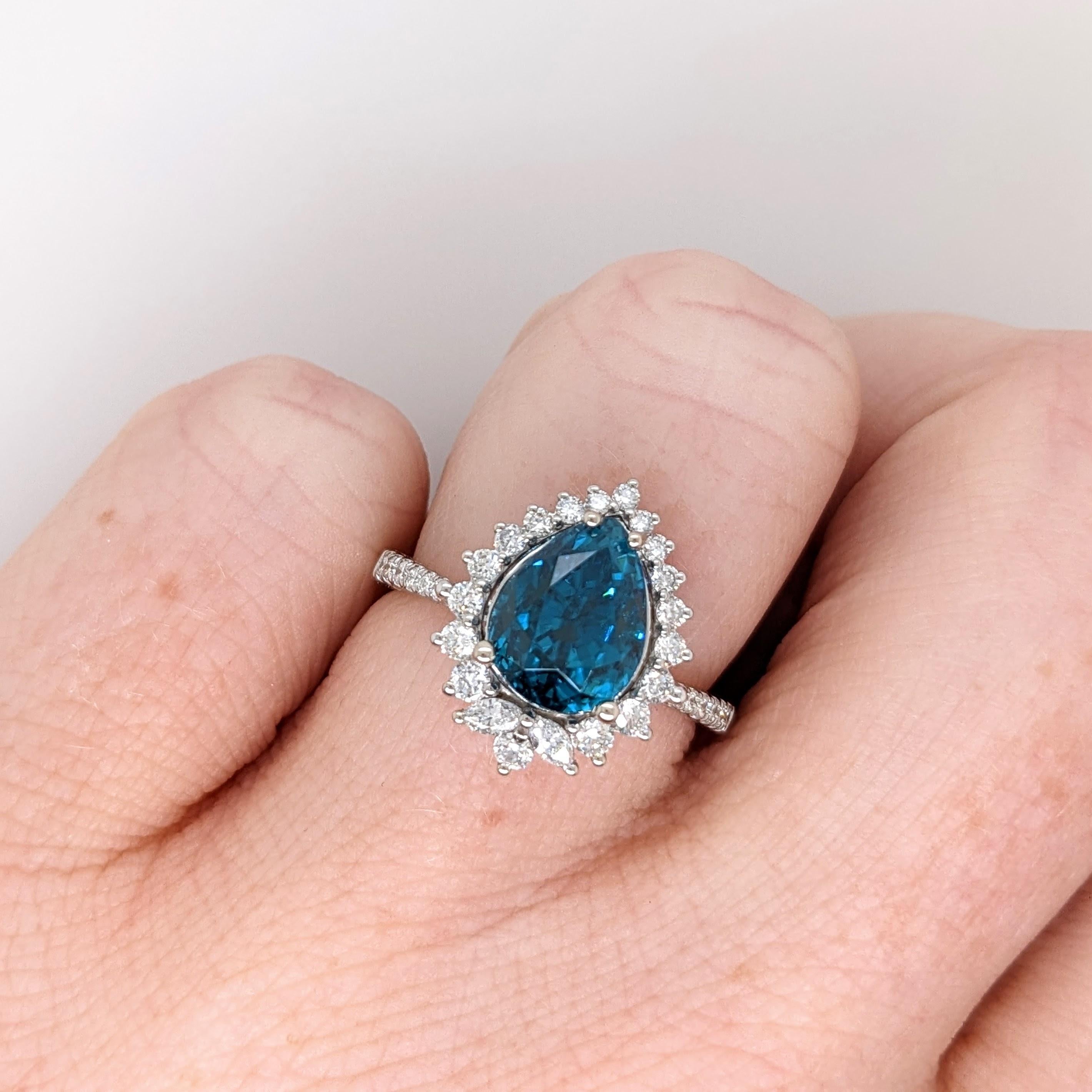 Cette bague est ornée d'un magnifique zircon bleu en forme de poire de 5,15 carats en or massif 14 carats et de diamants naturels extraits de la terre. Cette bague de collection est l'accessoire idéal pour tous les looks ! Cette bague est également