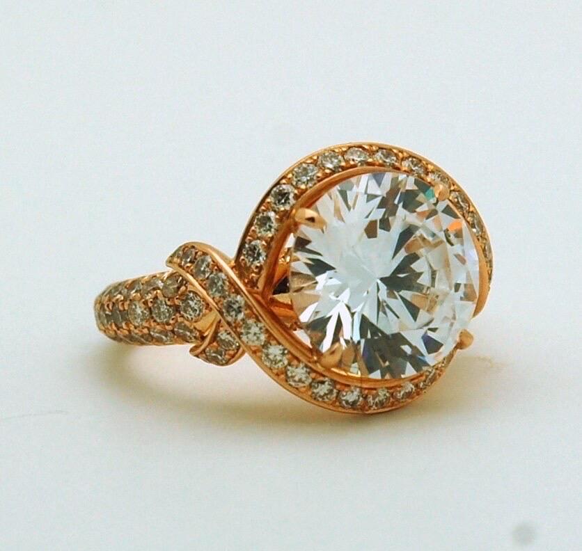5 carats moissanite made in a luxurious rose gold design, 18KT gold, VS diamonds/F color and craftsmanship that will last you decades. This ring is stunning! The moissanite will come with a certificate the clarity is VVS and color is D-E-F. This