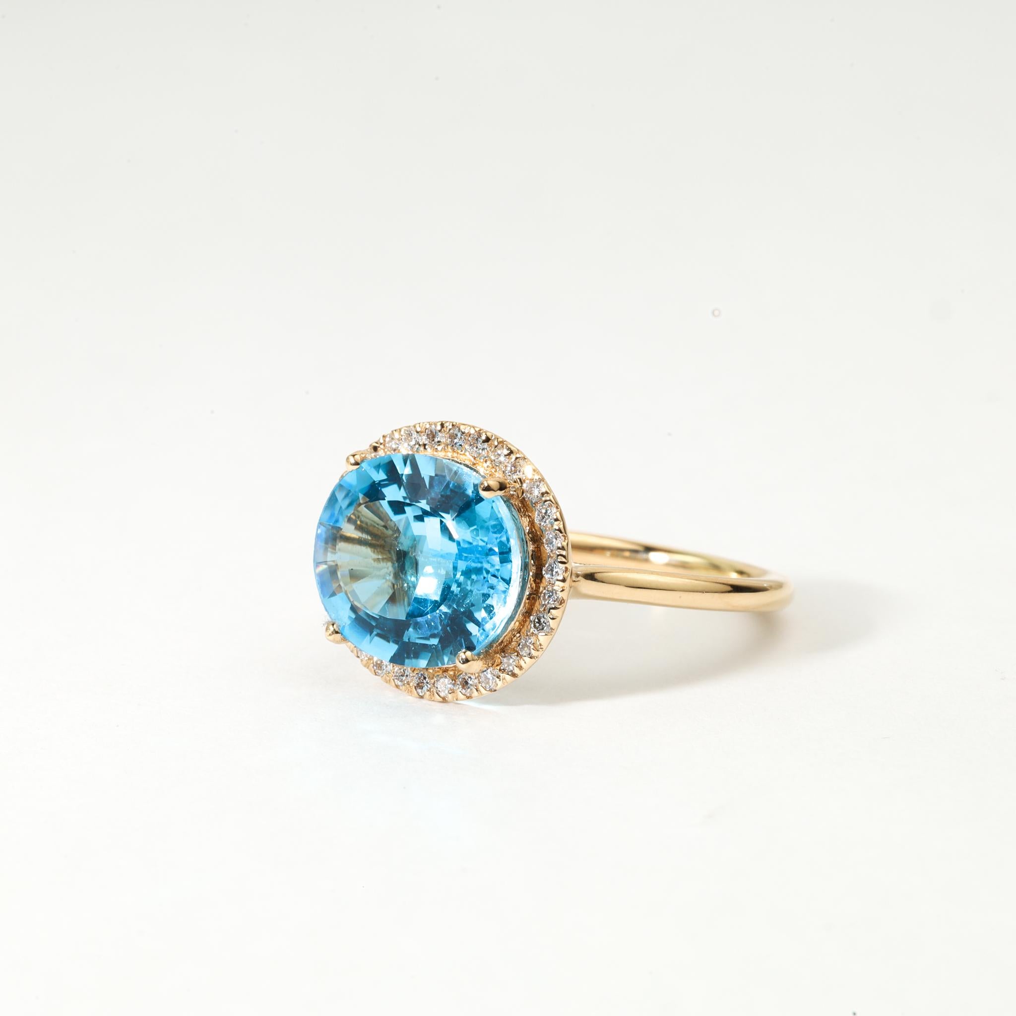 💎 Description du produit :
Radieuse et captivante, cette bague de fiançailles Halo est ornée d'une époustouflante topaze bleue suisse naturelle de 5 ct de taille ovale (12 × 10,2 mm), prisée pour son éclat bleu océan. La pièce centrale est entourée