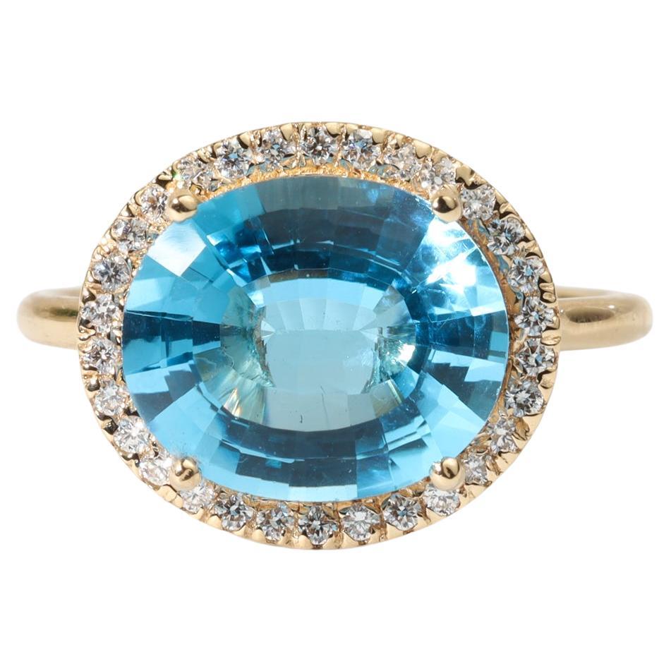 Bague de fiançailles en or jaune 18 carats avec topaze bleue suisse de taille ovale et diamant en halo en vente