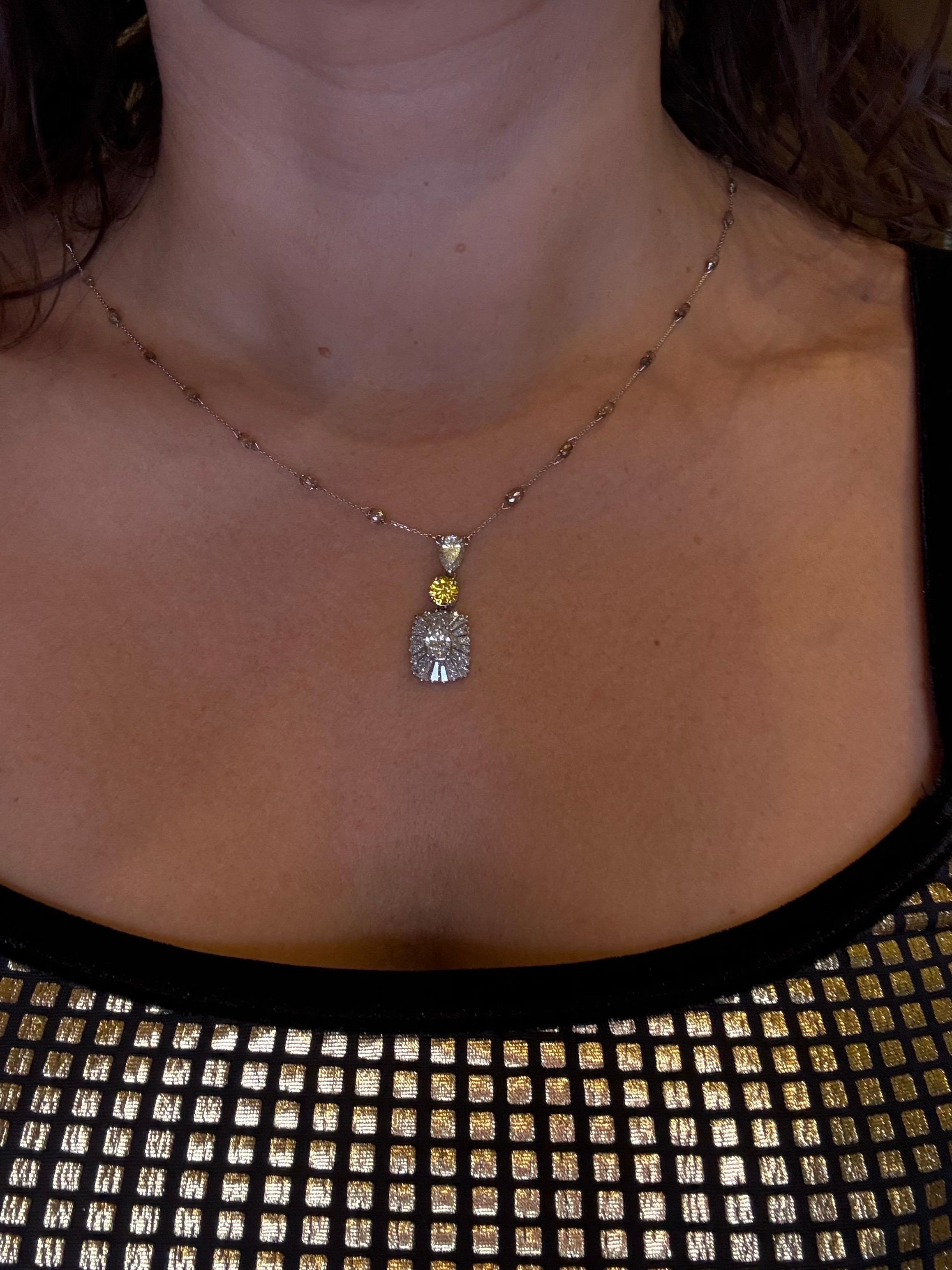 Splendida collana con pendente di diamanti da 5 carati, con tre diamanti al centro di colore giallo intenso SI2, un brillante rotondo e un brillante a pera accompagnati da baguette e rifiniti con diamanti briolette color champagne sulla catena.