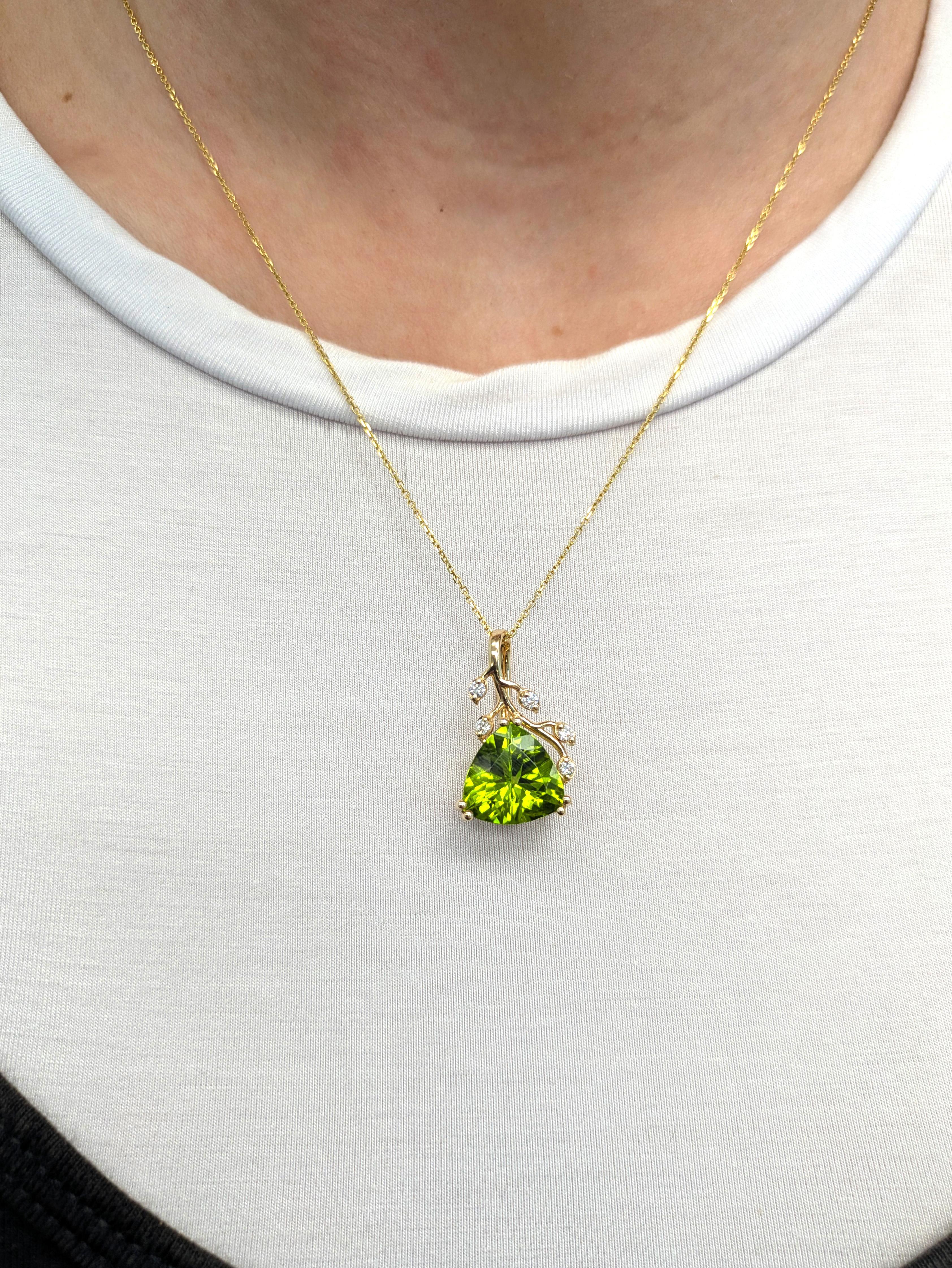 Celebrate vibrant beauty with this 5-carat trillion peridot pendant, accented by sparkling natural diamonds. Crafted in genuine 14K yellow gold, its vine-inspired bail adds an enchanting, botanical touch to this refined statement piece.


