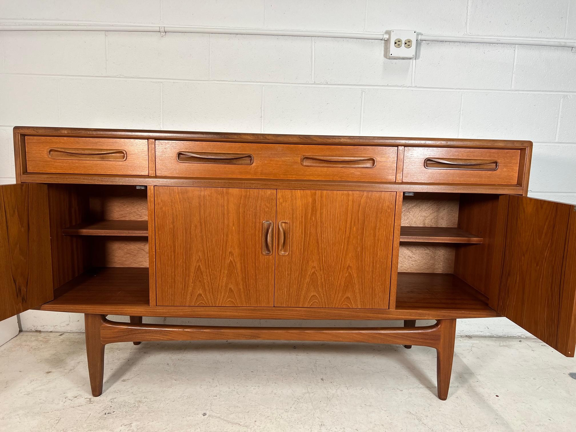 Outstanding small teak credenza. It was designed in the 1960s by Victor Bramwell Wilkins for G Plan's Fresco Range. It has original grey baize and wood dividers in the top drawer. Wood dividers can be removed. Adjustable shelves inside the