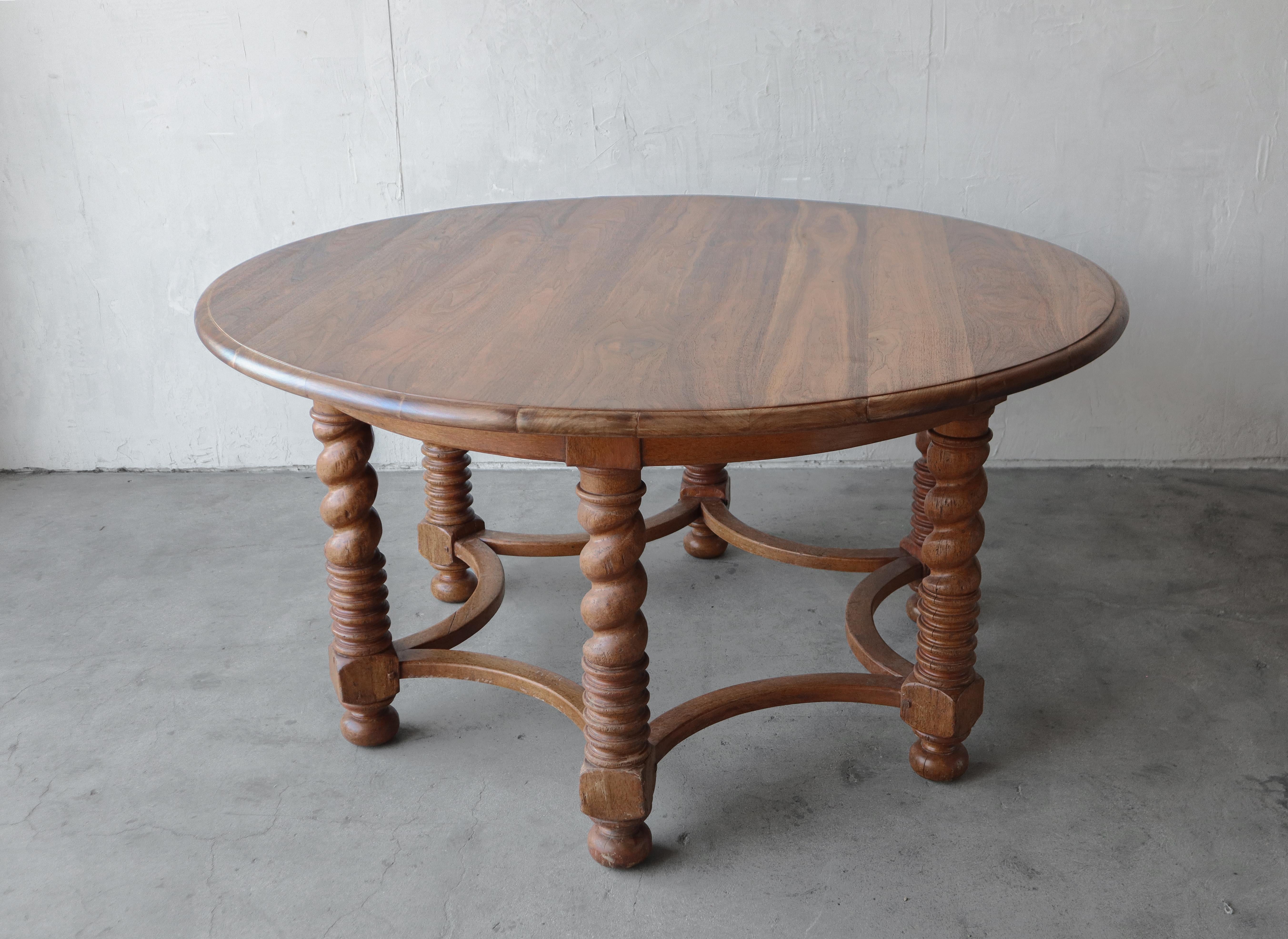 This European beauty is large in size and character.  This grand table features a large round top supported by six barley twist style legs connected by a rare rounded trestle base. The walnut top is beautiful and smooth contrasted by a more