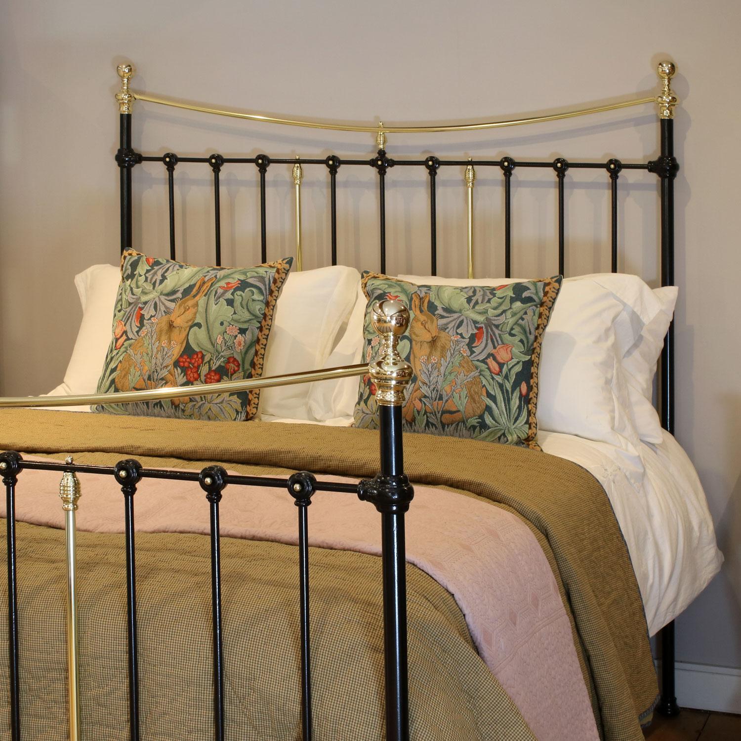 Victorian cast iron and brass bedstead in black with decorative castings with brass details and curved brass top rails. 

This bed accepts a UK King size or US Queen size (5ft, 60in or 150cm wide) base and mattress set.

The price includes a