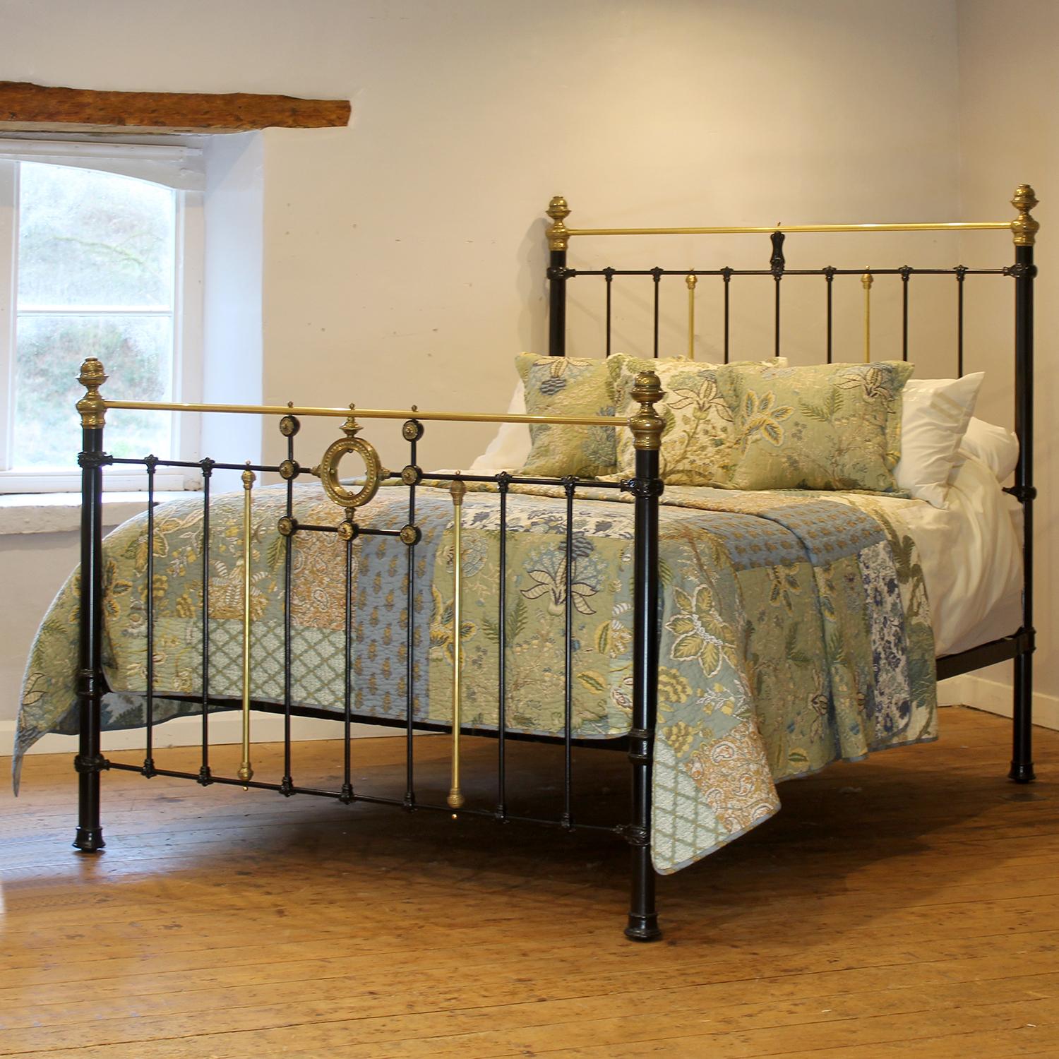 A superb cast iron antique bed finished in black with decorative features including brass rosettes and a large central ring in the footboard. 

This bed accepts a UK king size or US queen size (5ft, 60in or 150cm wide) base and mattress set.

The