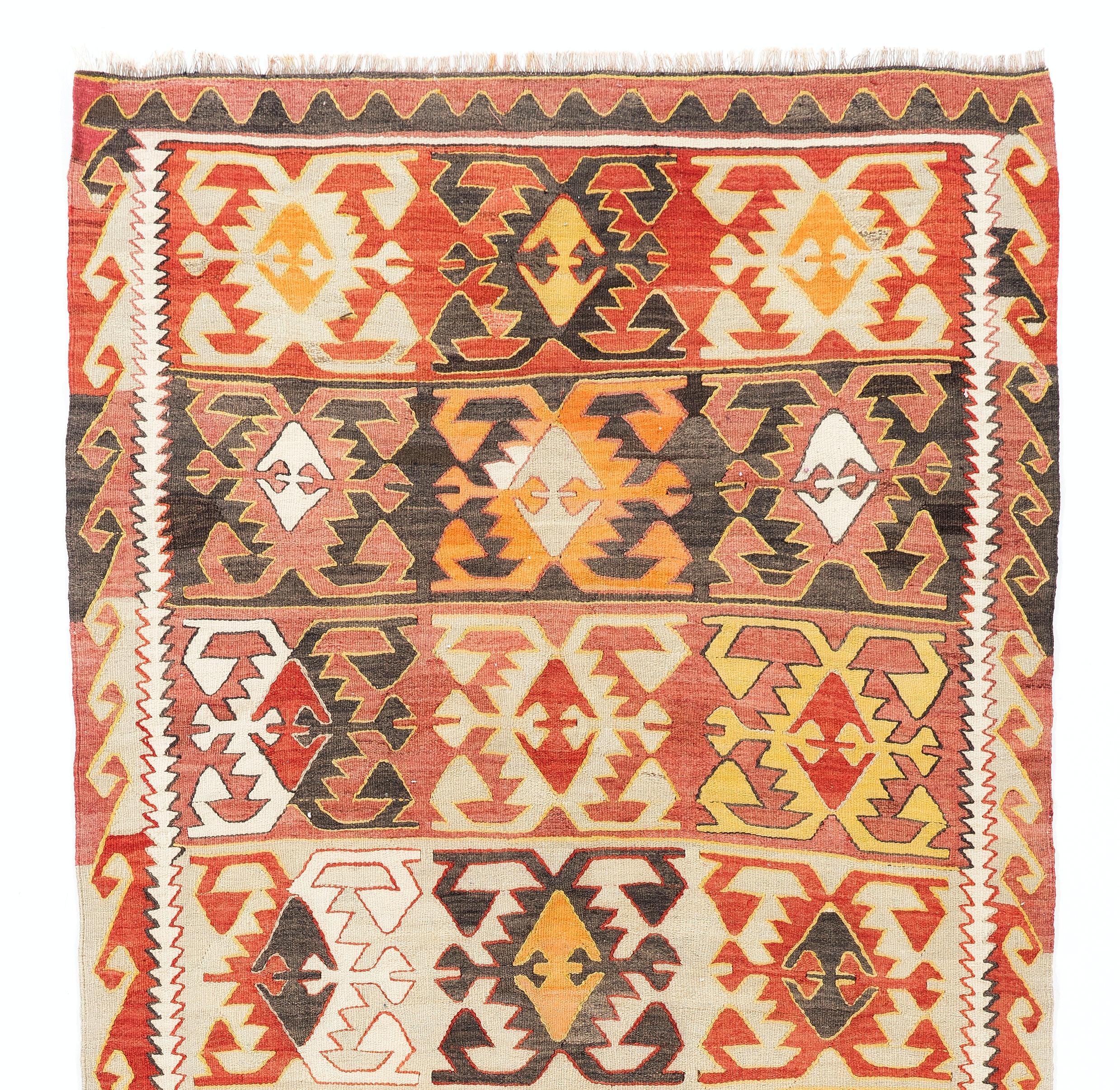 A vintage Central Anatolian Kilim (flat-woven rug) in a very warm, sun kissed color palette of terra cotta red, tomato red, burnt orange, bright orange, yellow, ivory as well as brown and very light aqua green. It features a unique design of