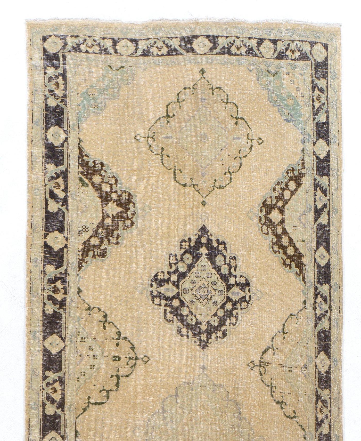 A vintage Turkish runner rug for hallway decor. It was hand-knotted in the 1960s with low wool on cotton foundation and features a multiple medallion design. It is in very good condition, professionally-washed, sturdy and suitable for areas with