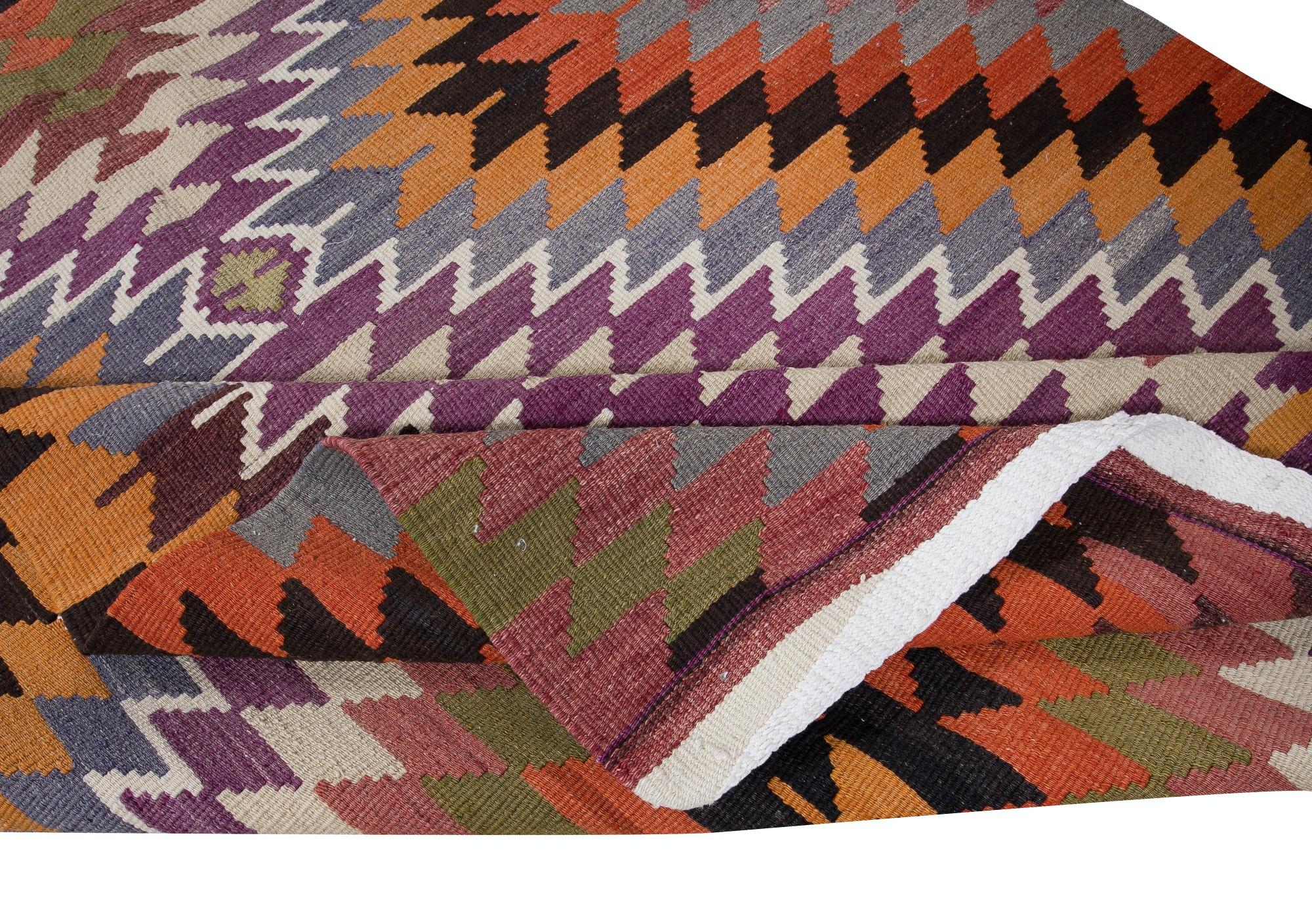 Embark on a journey through Turkish tradition with this exquisite vintage handwoven Turkish wool kilim rug, a testament to the enduring craftsmanship of Anatolian artisans. Woven with meticulous care and attention to detail, this kilim rug