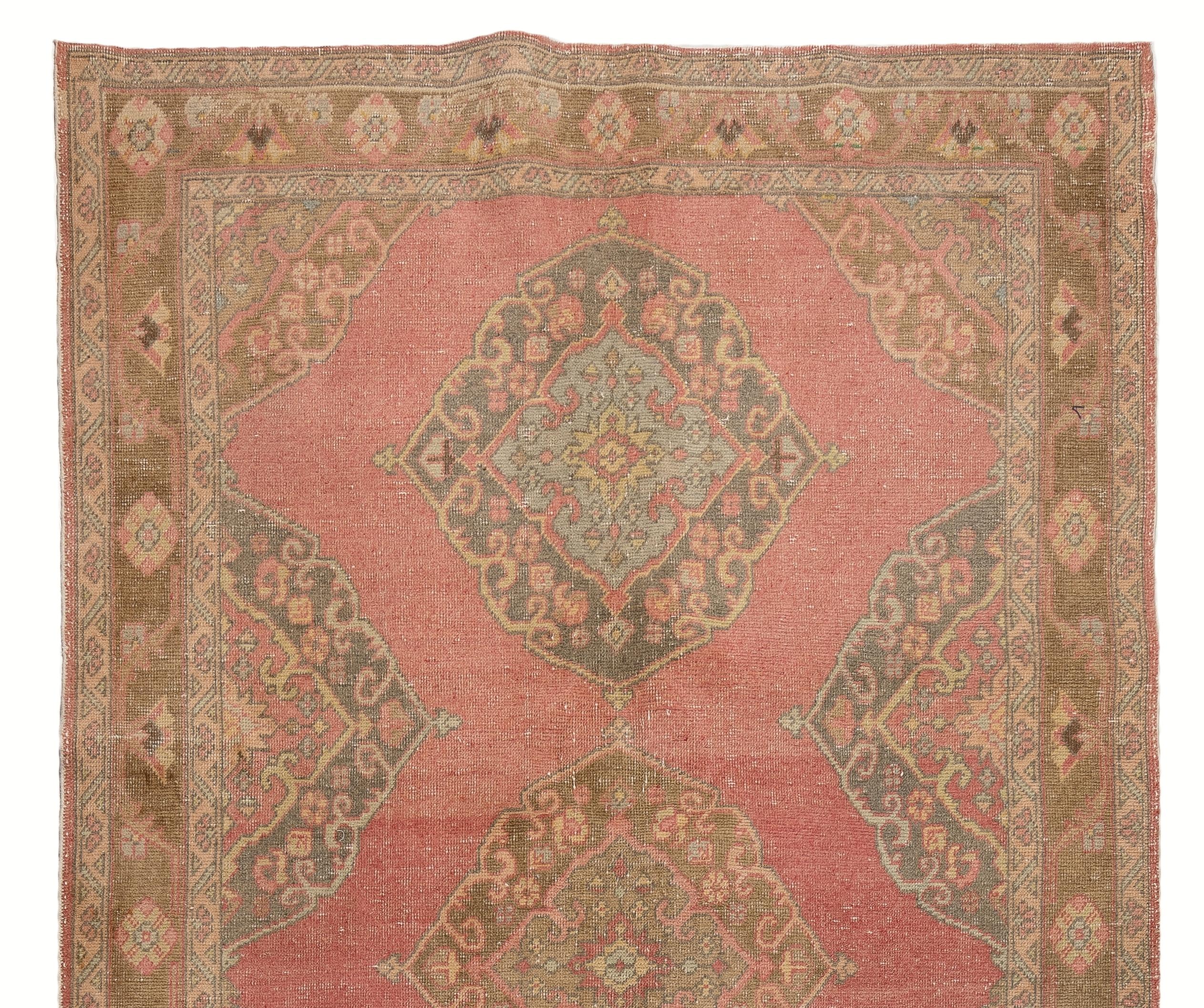 A vintage runner rug from Turkey. It has distressed low wool pile on cotton foundation and features multiple medallion design in soft colors. It has been washed professionally, the rug is sturdy and can be used in both residential or commercial