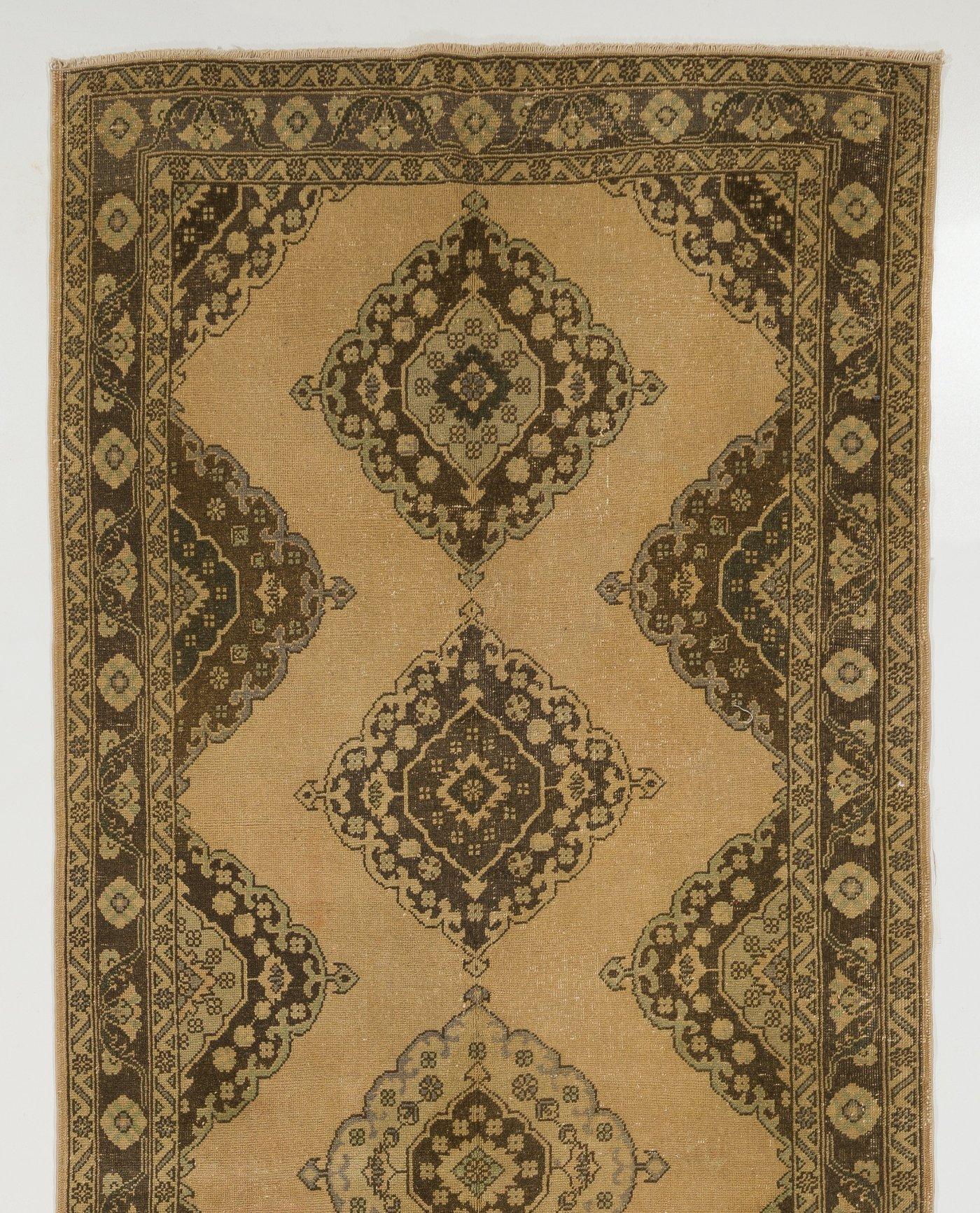 A vintage Turkish runner rug in neutral colors. It was hand-knotted in the 1950s with low wool on cotton foundation and features a multiple medallion design. It is in very good condition, professionally-washed, sturdy and suitable for areas with