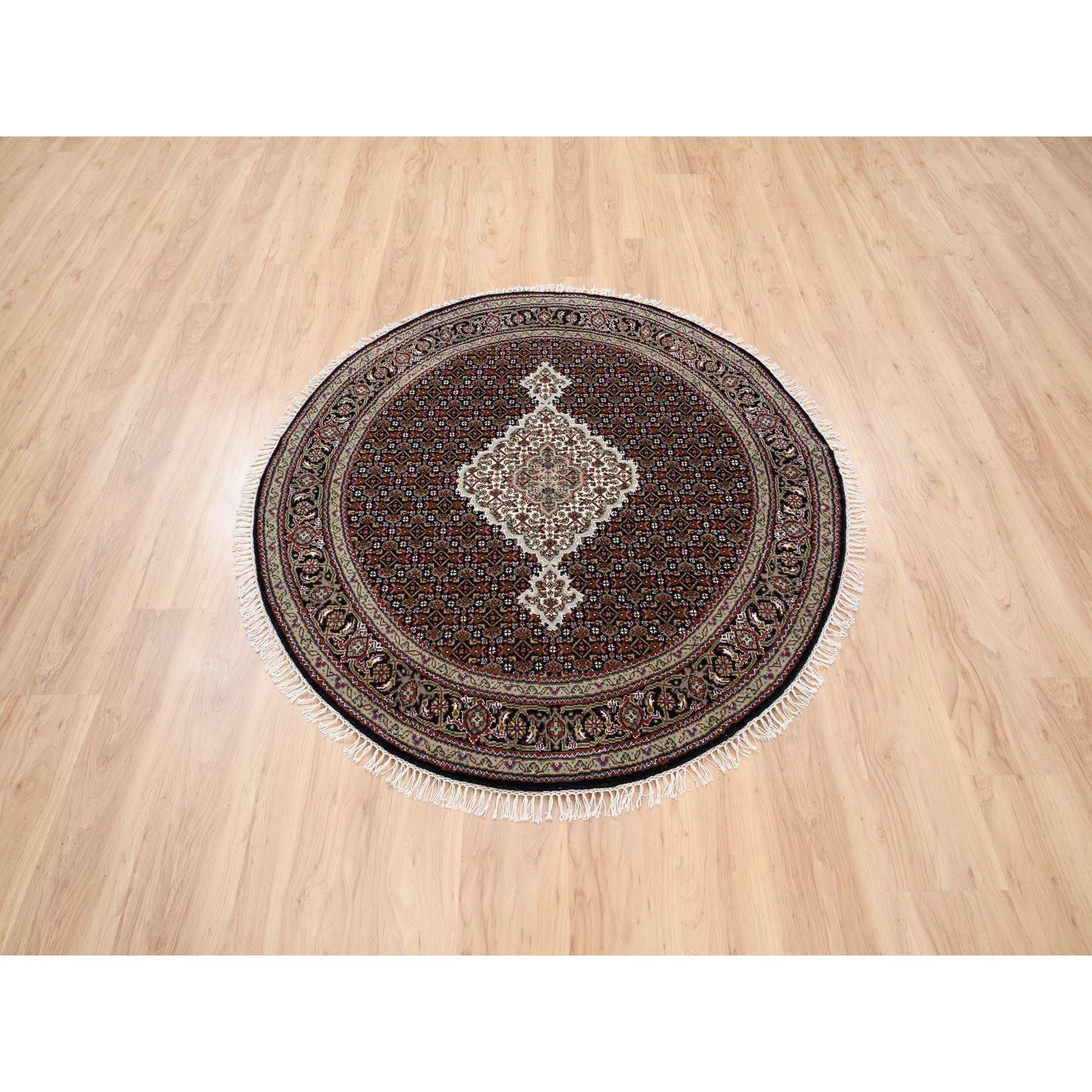 This is a truly genuine one-of-a-kind 175 KPSI Hand Knotted Rich Black Tabriz Mahi with Fish Medallion Design Wool Oriental Round Rug. It has been Knotted for months and months in the centuries-old weaving craftsmanship techniques by expert