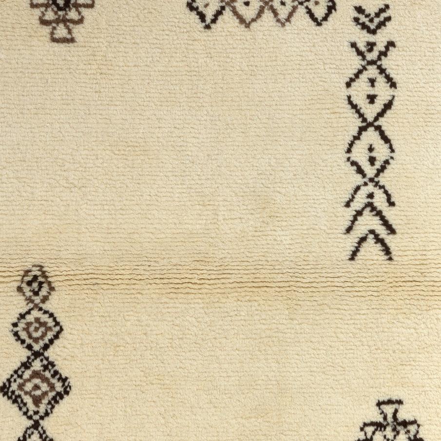 Dieser moderne, handgeknüpfte marokkanische Teppich zeichnet sich durch ein spärliches, geometrisches Rautenmuster aus. Er besteht aus hochwertiger, ungefärbter, handgesponnener, luxuriöser Schafwolle mit einem dichten, weichen Flor.
Der Teppich ist