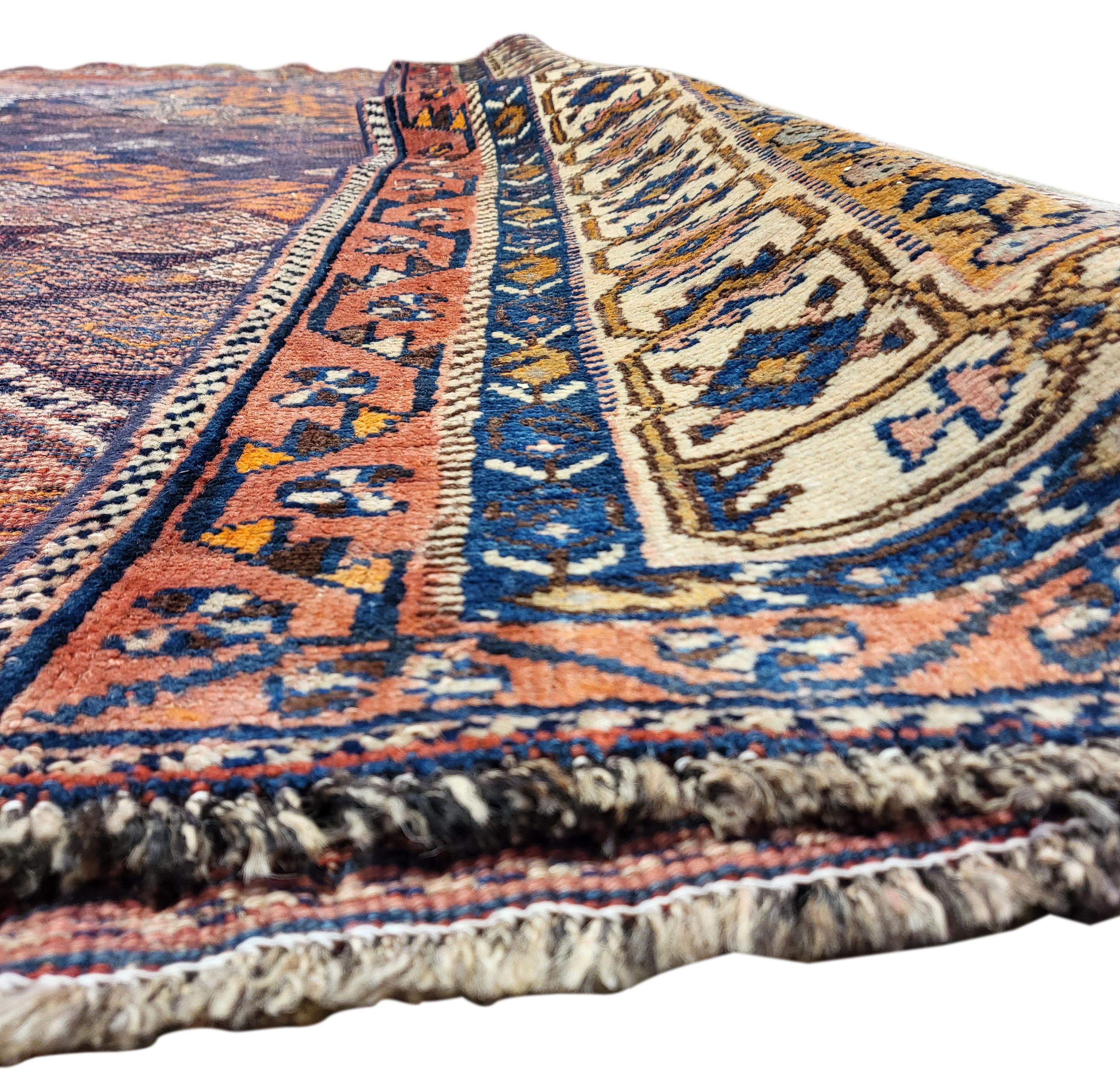 Magnificent 1930's Persian Lori. For nearly a century this rug's beauty has stood the test of time! The beautiful rusty tones enhanced by the navy foreground of this rug are incredibly sought after. Featuring a versatile tribal design that