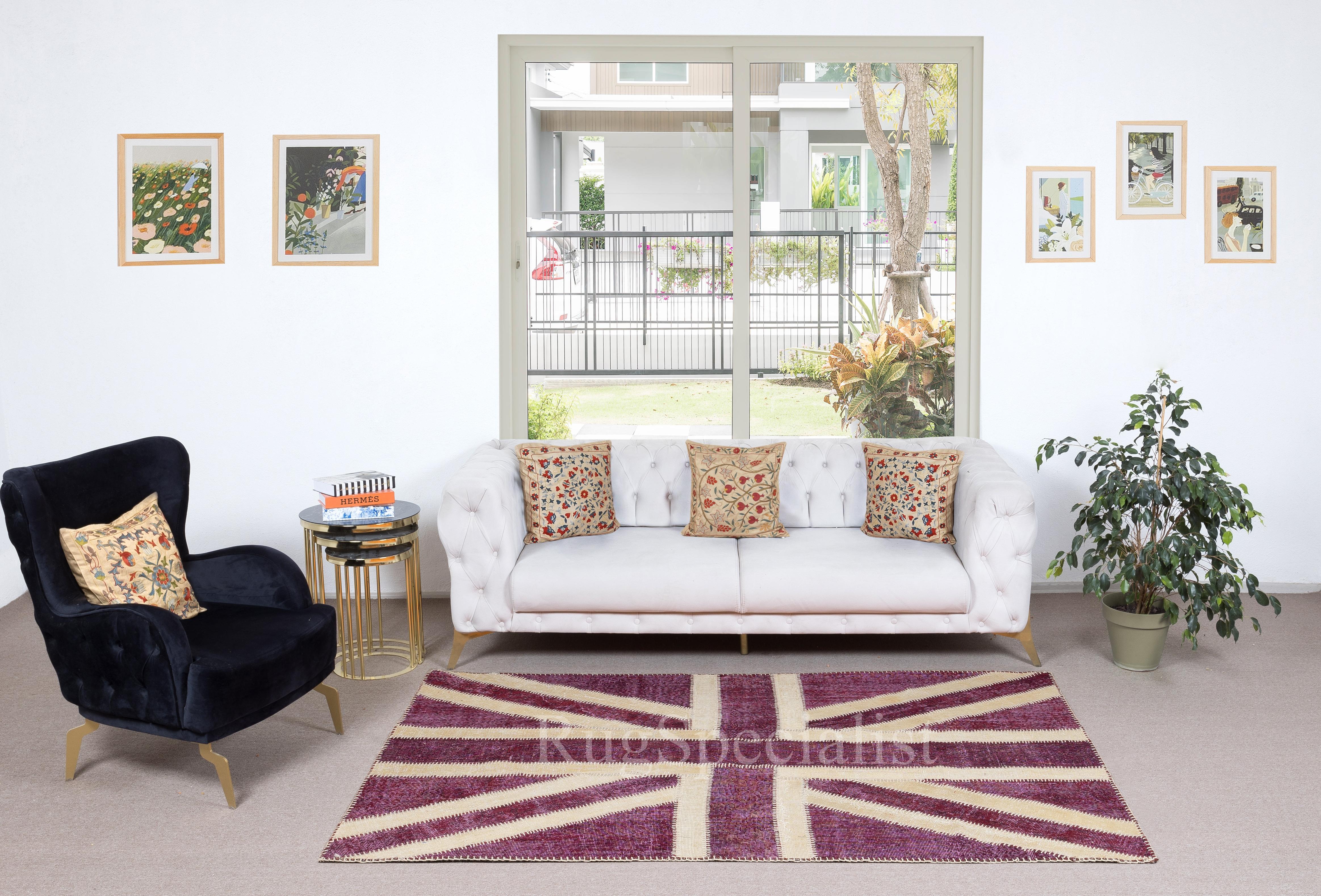 Dieser kühne Union Jack-Patchwork-Teppich wurde in meisterhafter Handarbeit aus sorgfältig ausgewählten alten türkischen Teppichen gefertigt, die in satten Rosa- und Elfenbeintönen eingefärbt wurden. Jedes Fragment, einst Teil eines anatolischen