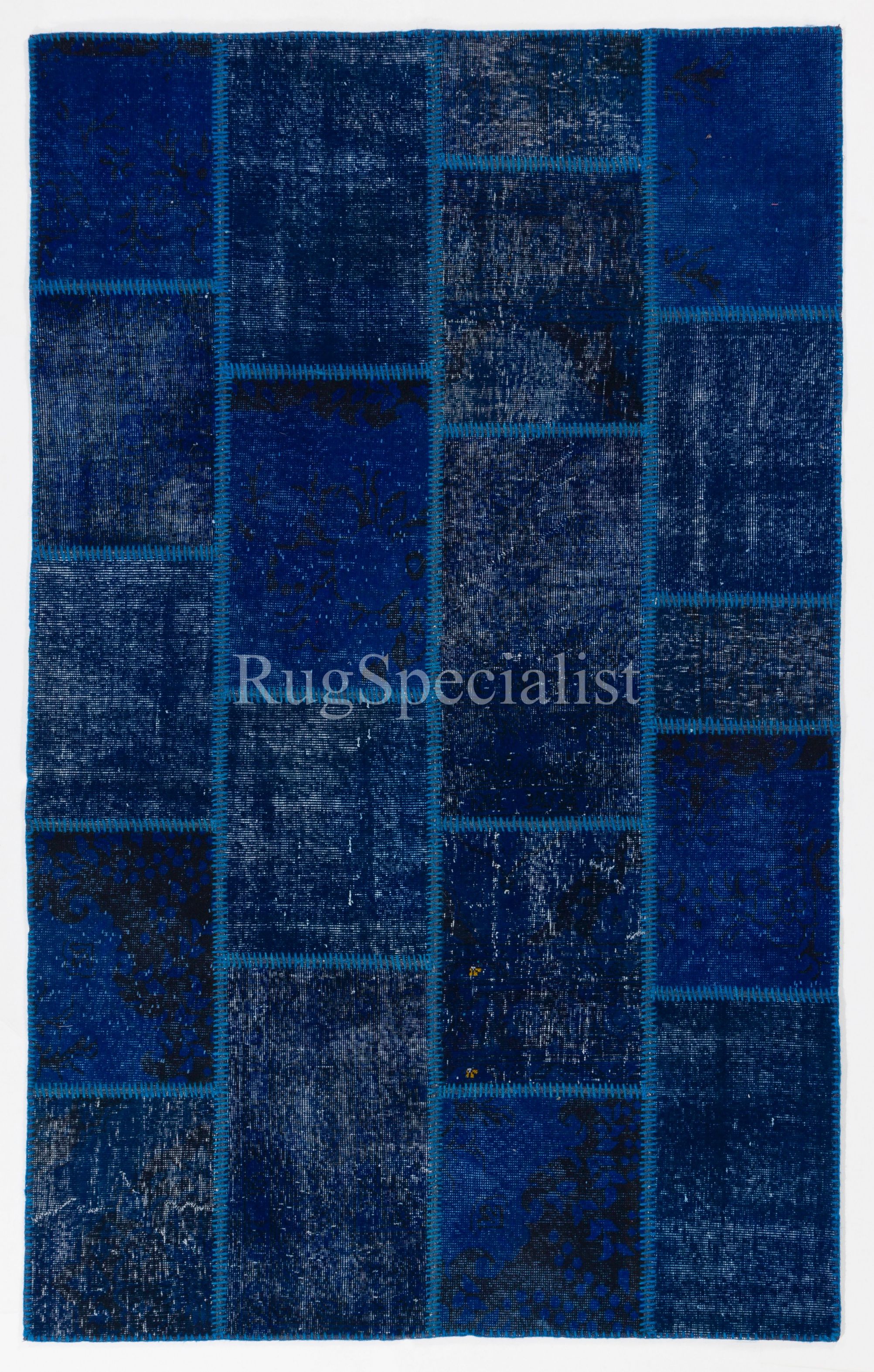 Assorted pieces of mid-20th century hand knotted Anatolian rugs were washed, sheared, re-dyed in various colors, cut into geometric shapes then stitched together by hand to create this beautiful one of a kind patchwork rug. A durable dark color