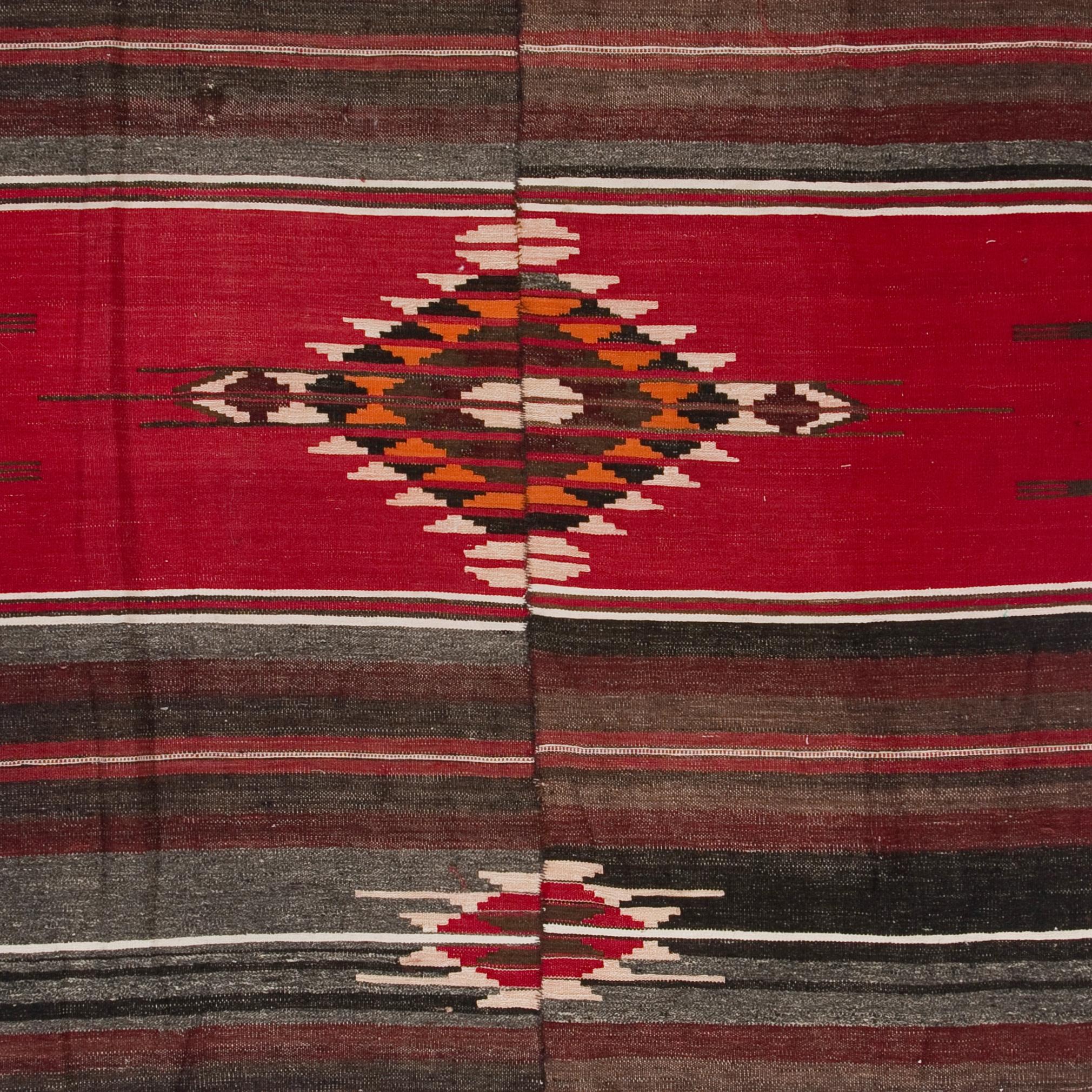 A simple yet beautiful wool rug handwoven by the nomadic tribes in South Central Turkey in the 1960s. This banded flat-weave/kilim was traditionally woven in two pieces and then hand-stitched. It features a striped design with stepped geometric