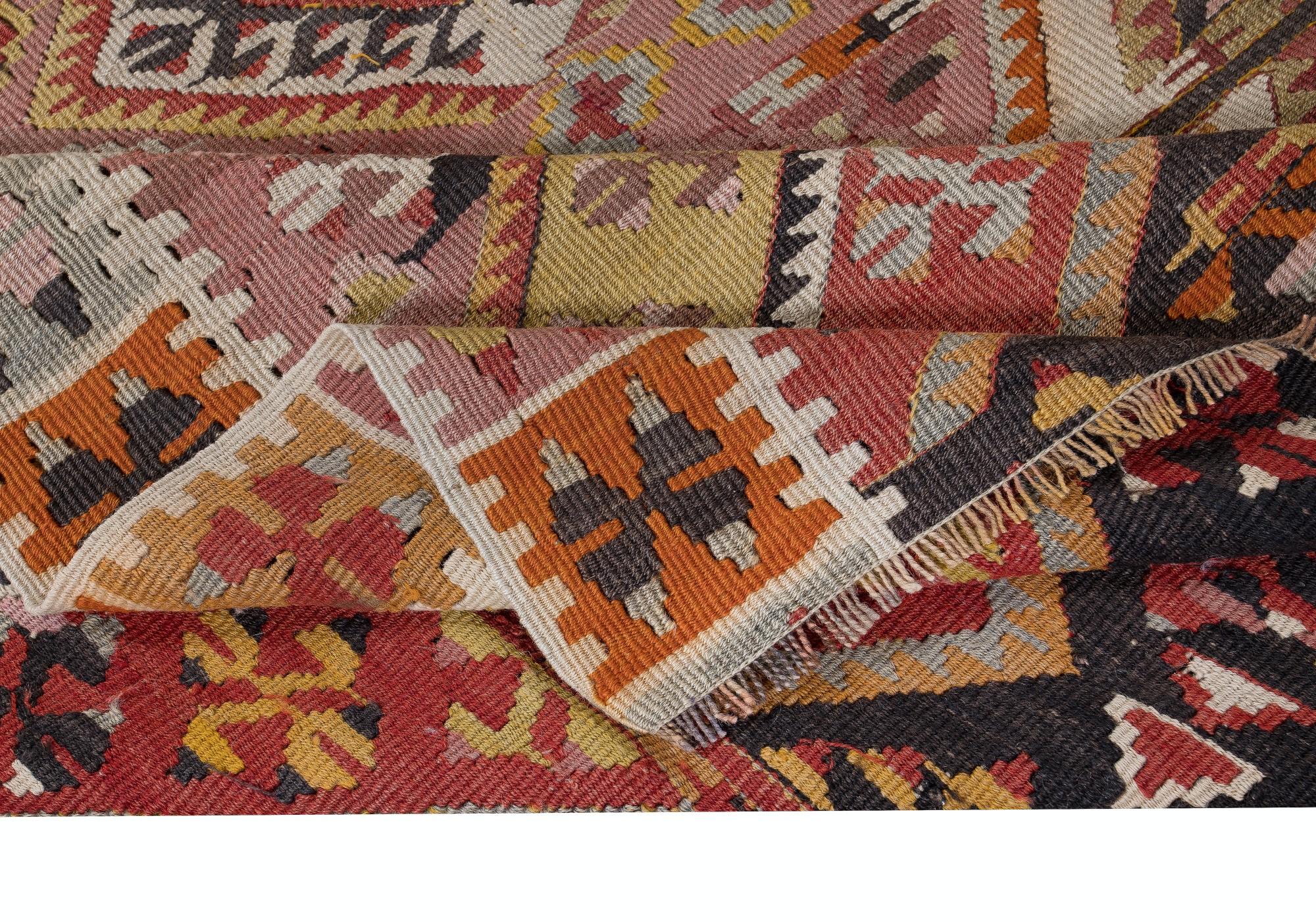 Embark on a journey through Turkish tradition with this exquisite vintage handwoven Turkish wool kilim rug, a testament to the enduring craftsmanship of Anatolian artisans. Woven with meticulous care and attention to detail, this kilim rug