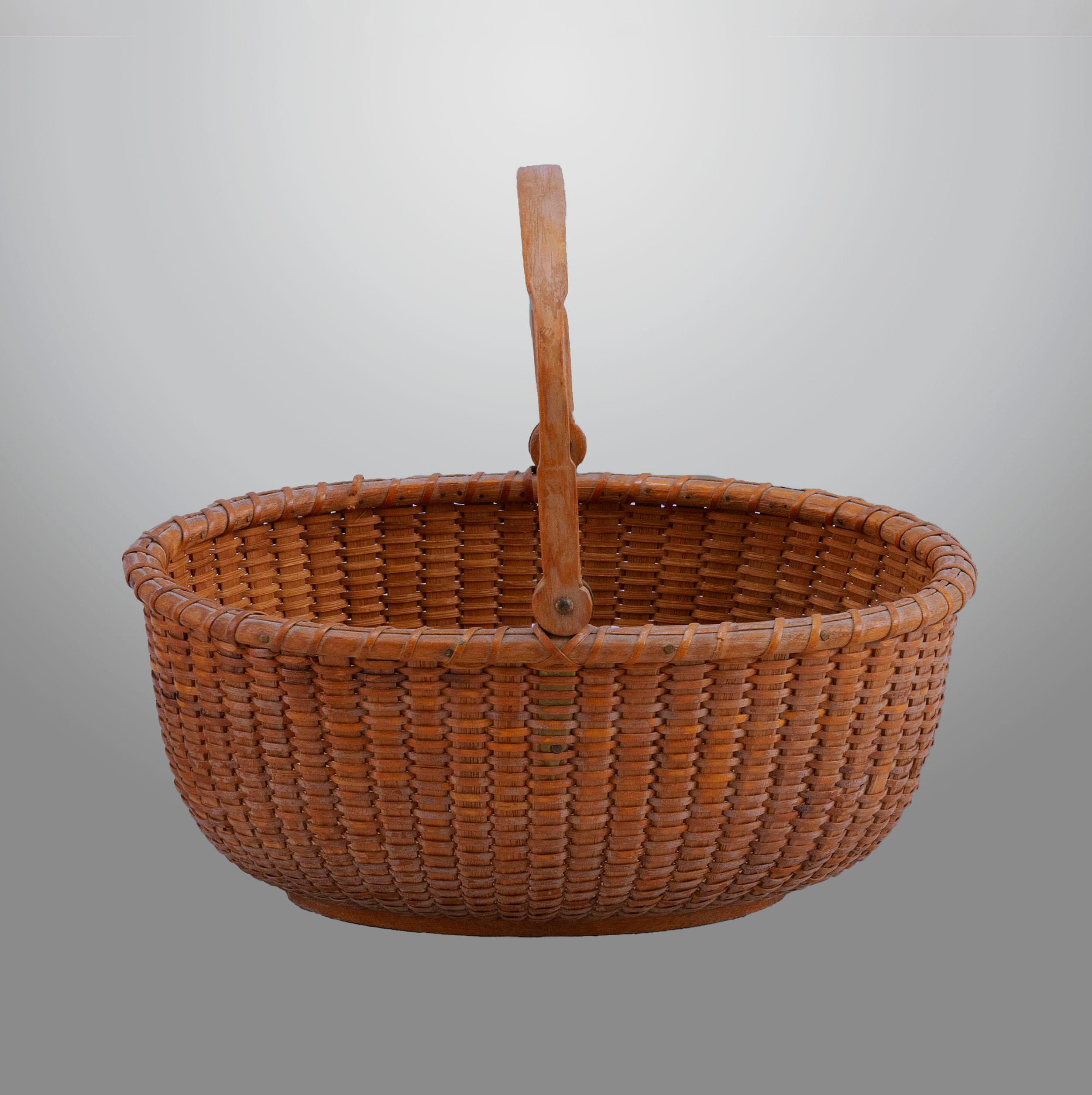 Oval Nantucket lightship basket with shaped oak swing handle
ending in carved round “lollipop” ends and brass ears. Remnants of
the original paper label remains on the bottom. Made by Davis
Hall (1929-1906), circa 1875
133. Measures: 6 ¼”. 