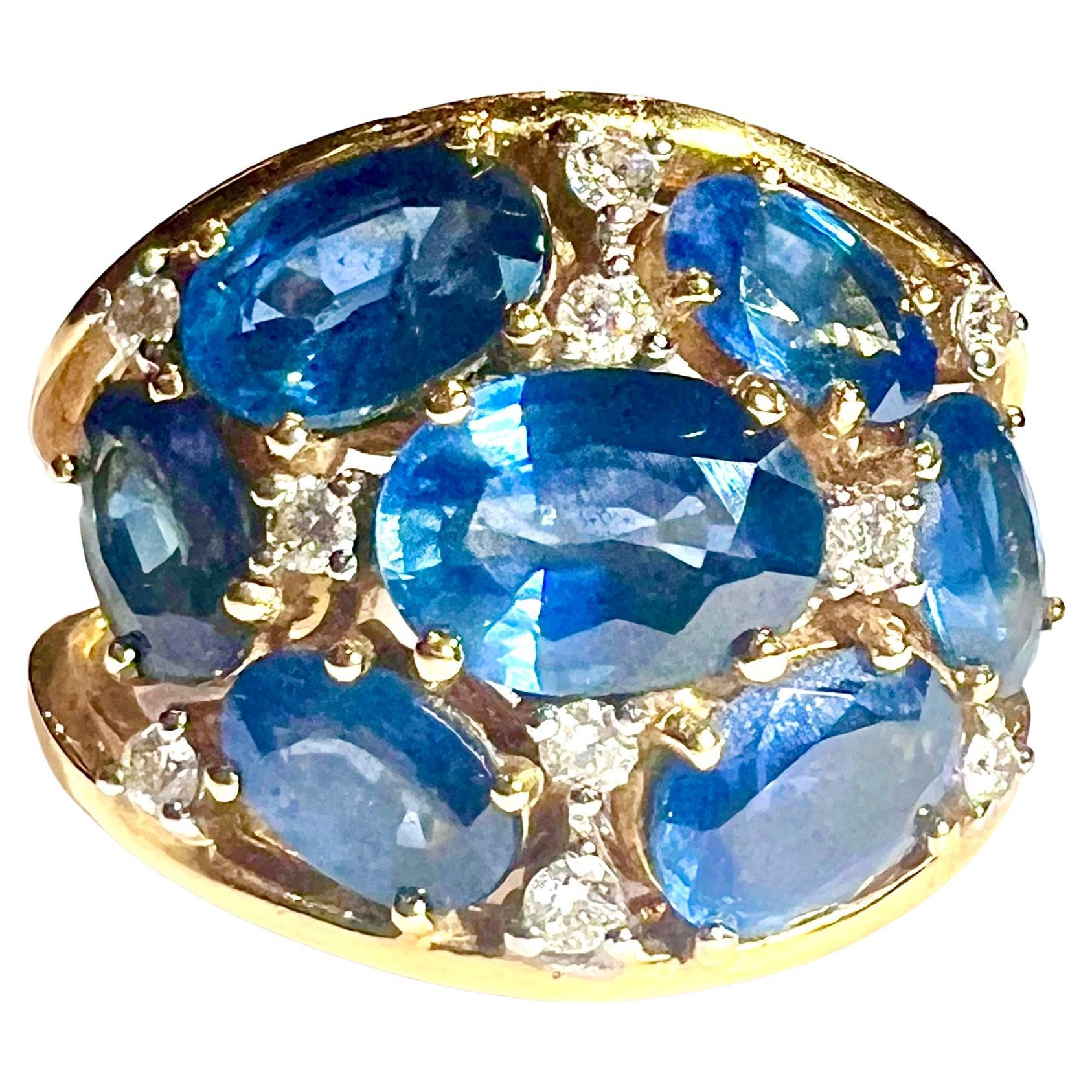 Bold and vibrant, this dome-shaped cocktail ring in 18K yellow gold radiates confident elegance. Its curved surface is set with seven richly colored sapphires, totaling 6.19 carats, arranged in a dynamic composition that enhances the depth and glow