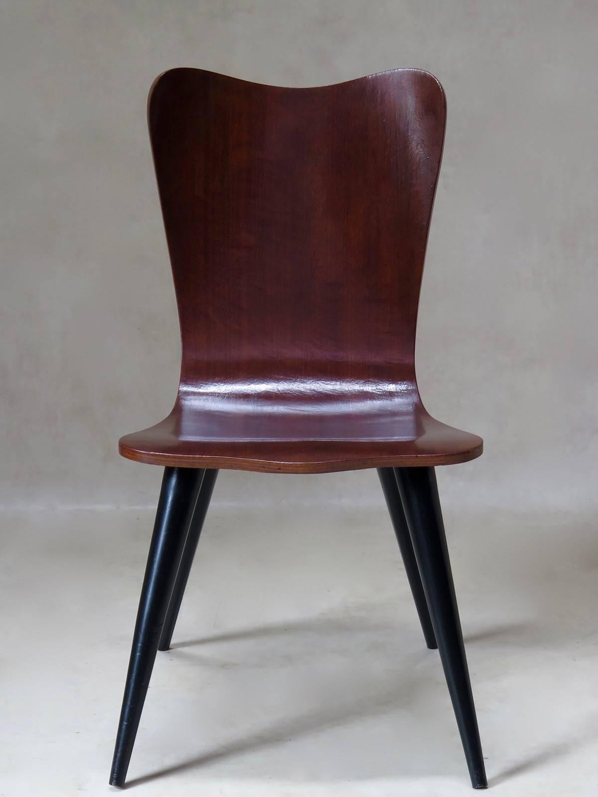 Set of six dining chairs with great allure, from the two tones of wood to the exaggeratedly tapered and splayed legs.