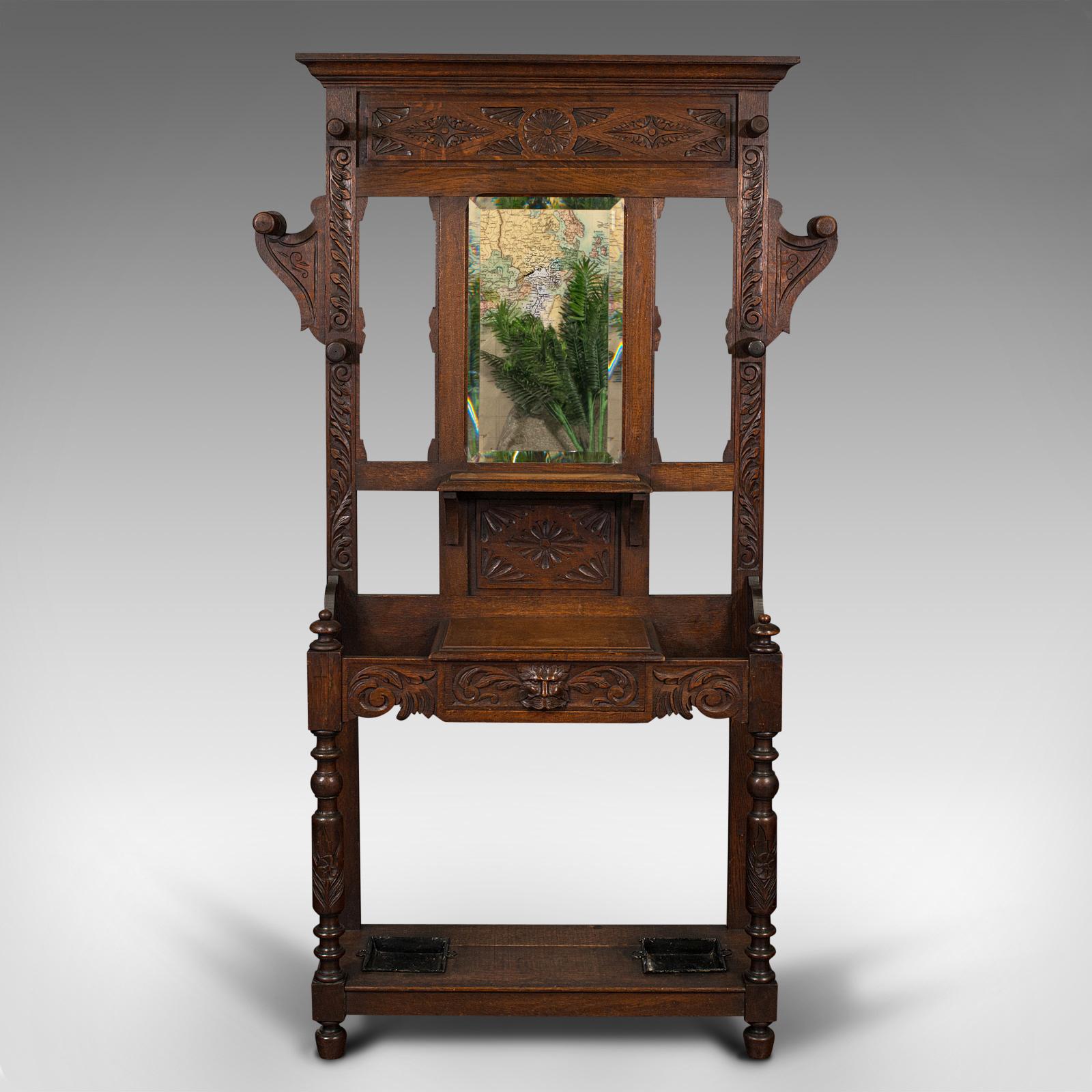 This is a tall antique hall stand. An English, carved oak stick and coat rack in Gothic revival taste, dating to the Victorian period, circa 1880.

Distinctive Gothic revival carvings decorate this striking stand
Displays a desirable aged patina