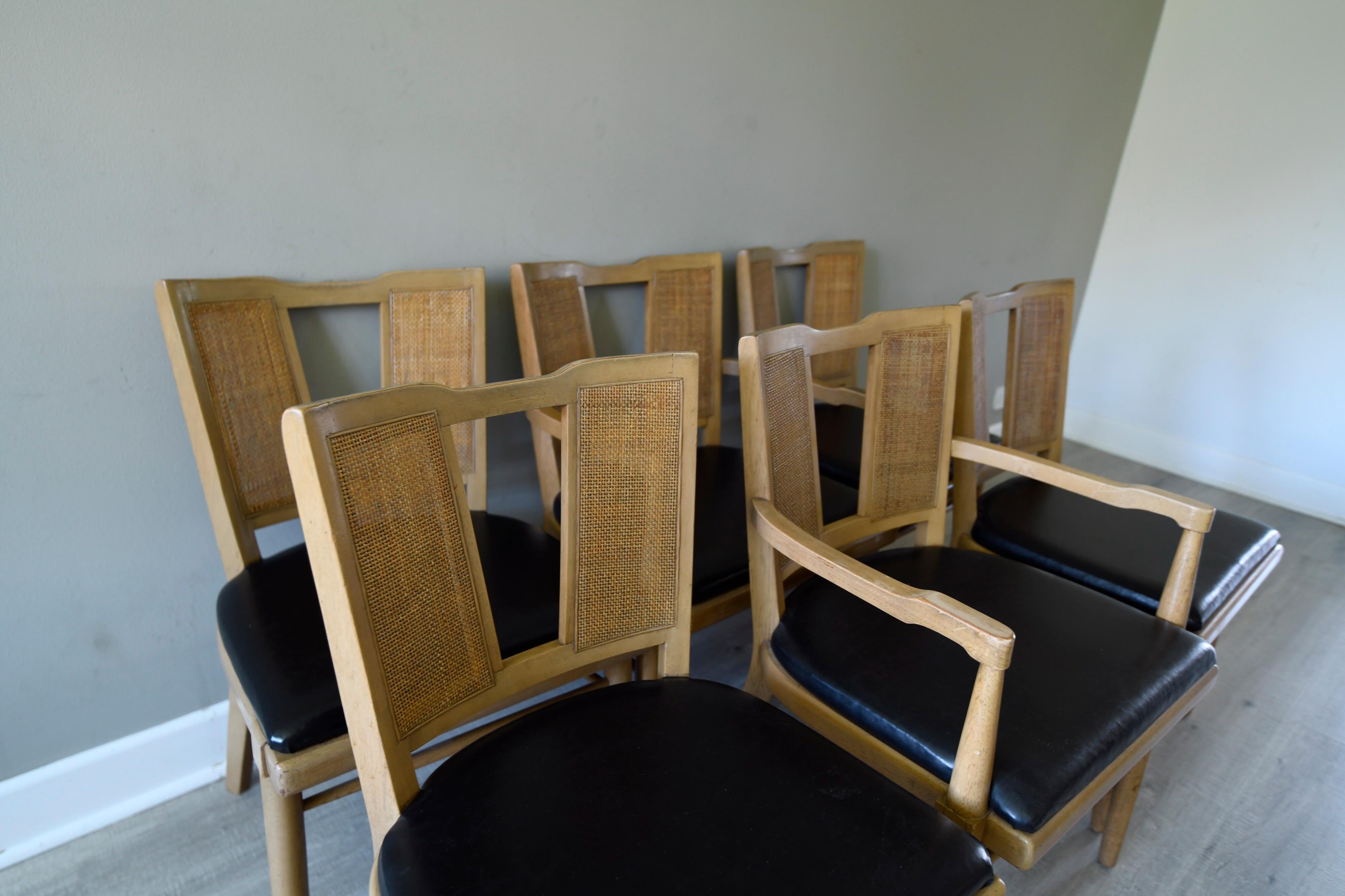 6 American of Martinsville dining chairs designed by Merton L Gershun with a sublime aged lacquer open caned weave backs 2 of the chairs being carvers it has Asian influences with a Hollywood Regency feel with original black vinyl.