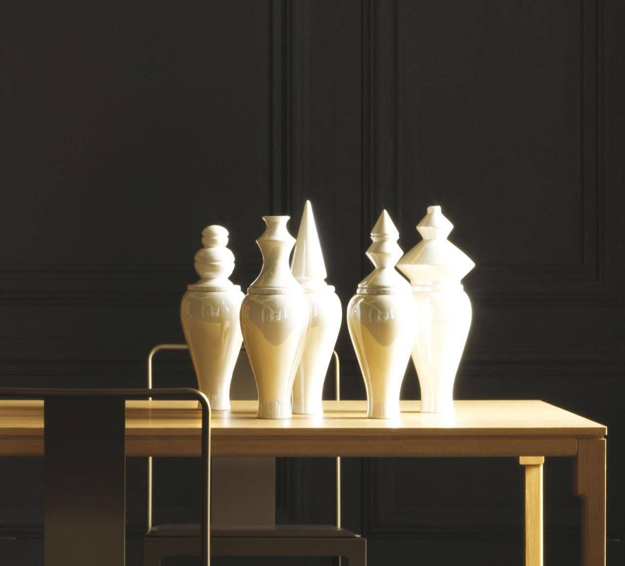 Die flüchtige und rätselhafte Kollektion besteht aus sechs verschiedenen perlmuttfarbenen Keramikdeckeln auf perlmuttfarbenen Keramikvasen. Die Kollektion 