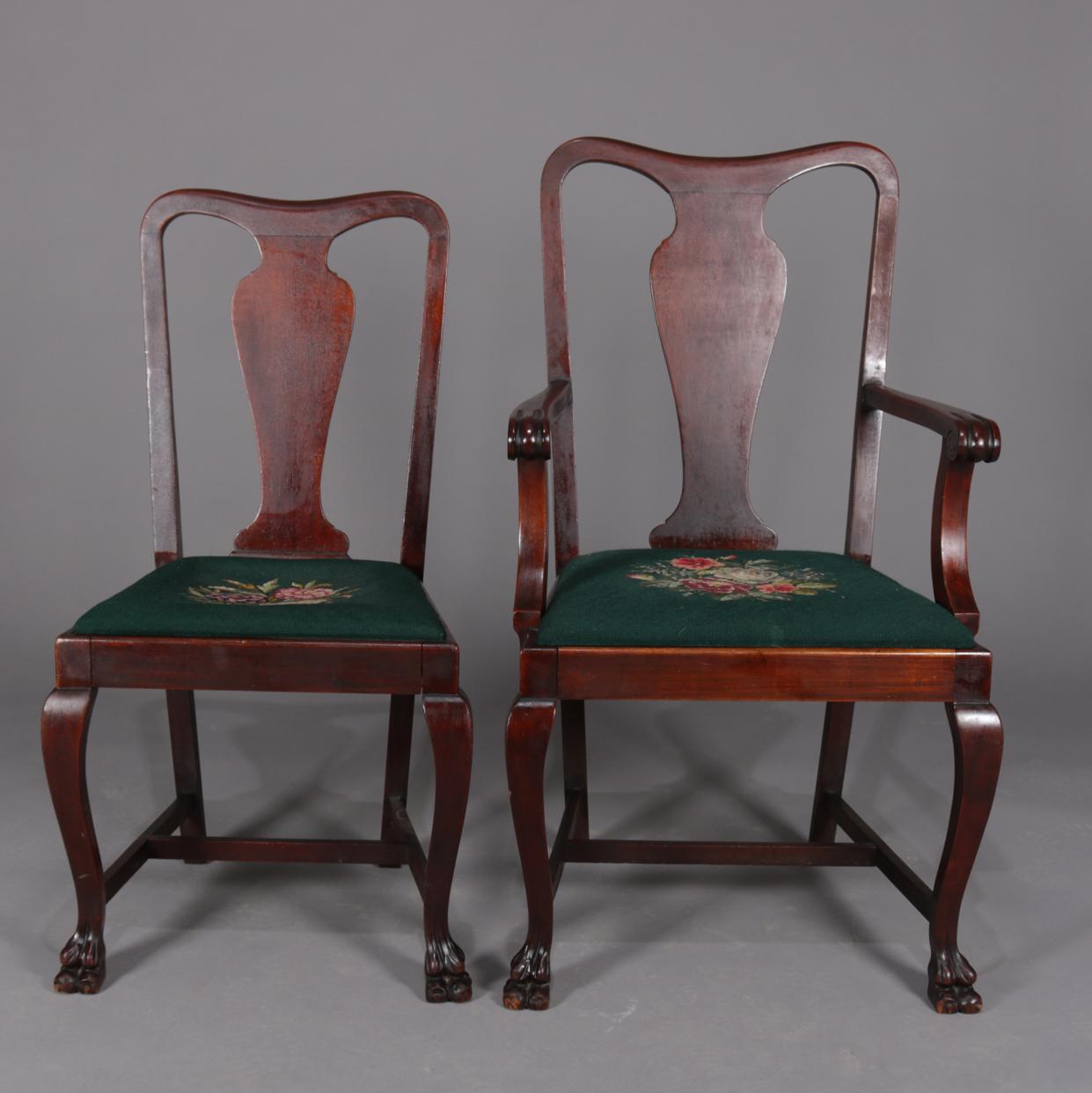 Set of 6 Chippendale style dining chairs feature mahogany frames with shaped plank splat backs, paw feet and floral needlepoint upholstered seats, set includes one armchair and five side chairs, circa 1920.

Measures: side chairs 38.5