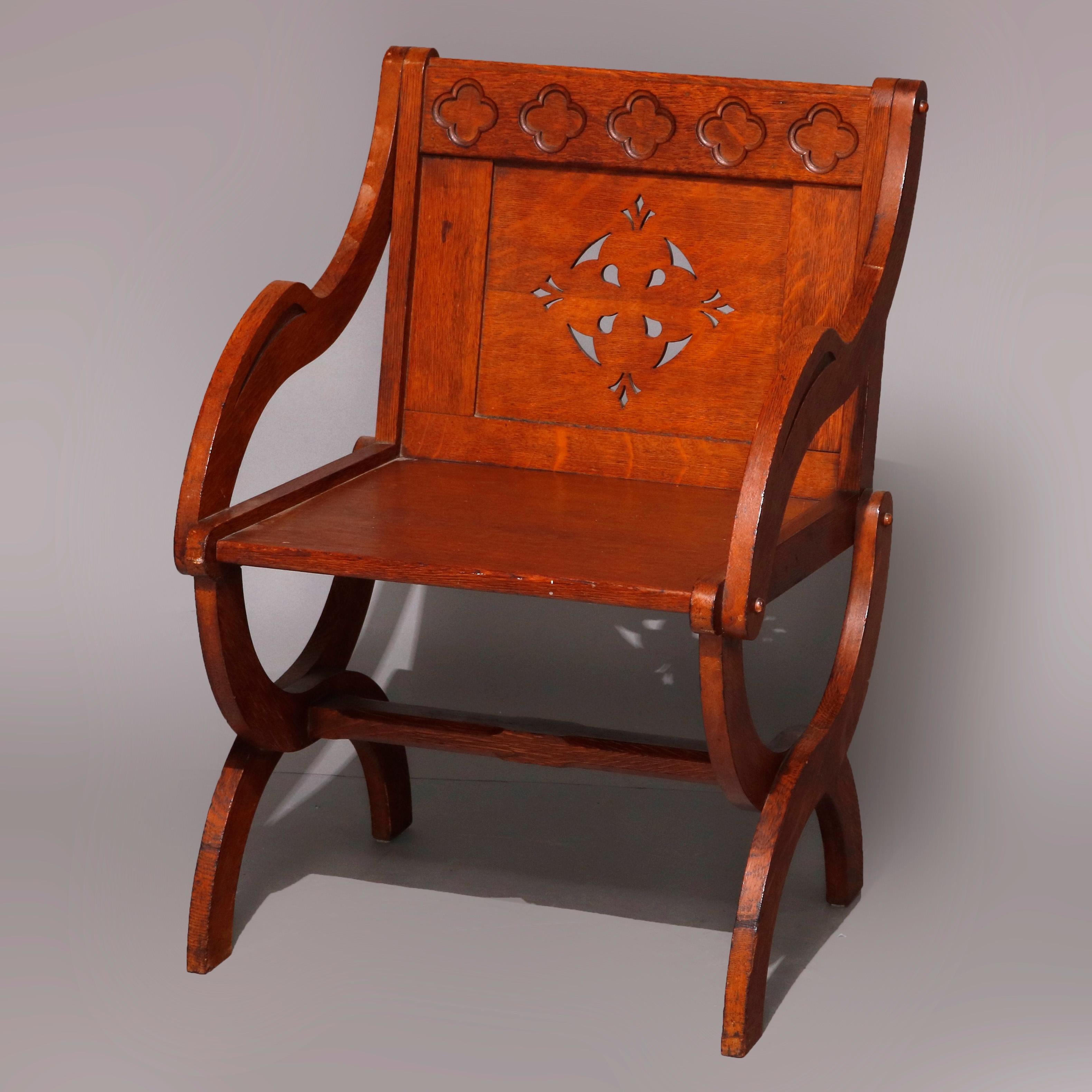 A set of six Gothic armchairs offers oak construction in stylized curule form with backs having carved stylized clovers in crest over pierced backs, curved arms and raised on X-form legs, circa 1900

***DELIVERY NOTICE – Due to COVID-19 we are