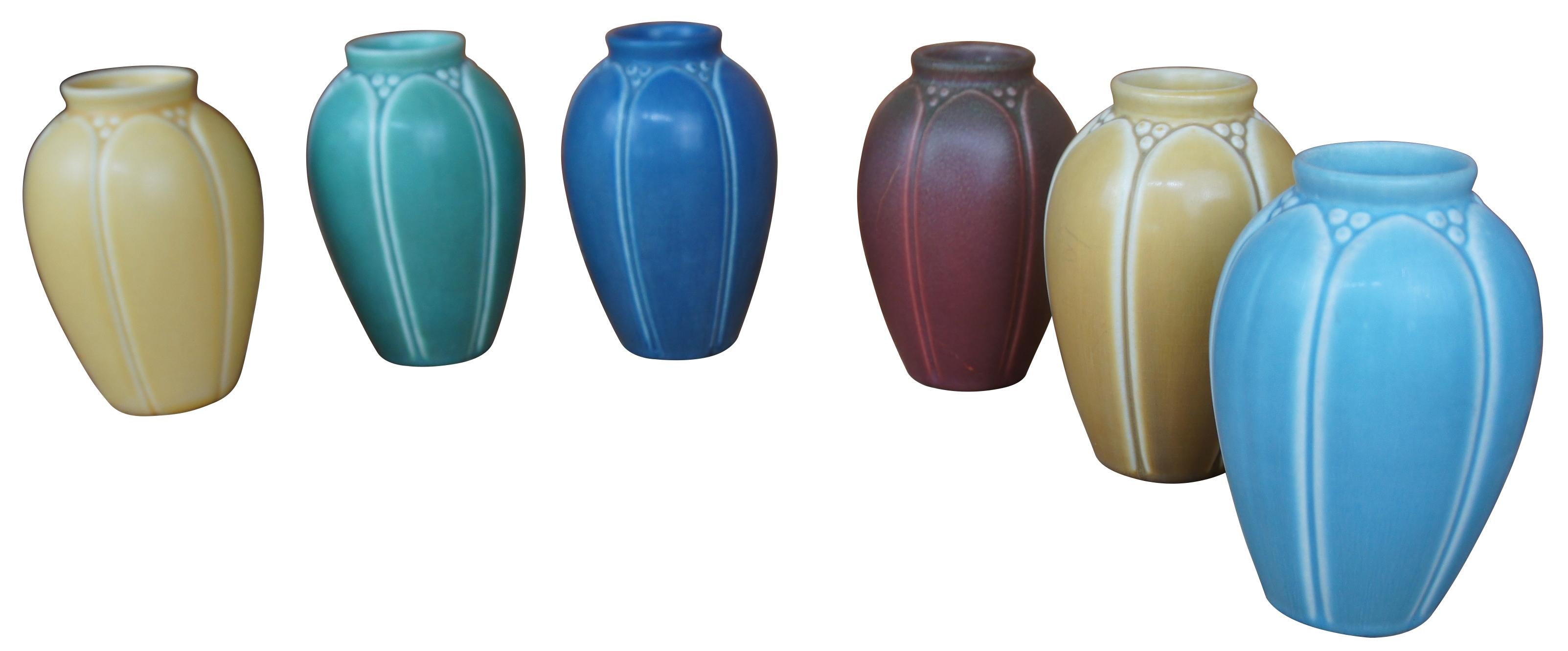 Six antique Rookwood vases in a rainbow of colors showing Victorian arts and crafts styling with matte glaze. Vases marked on base, 1917, 1921, 1923, 1928, and two marks were covered by glaze. Measure:6