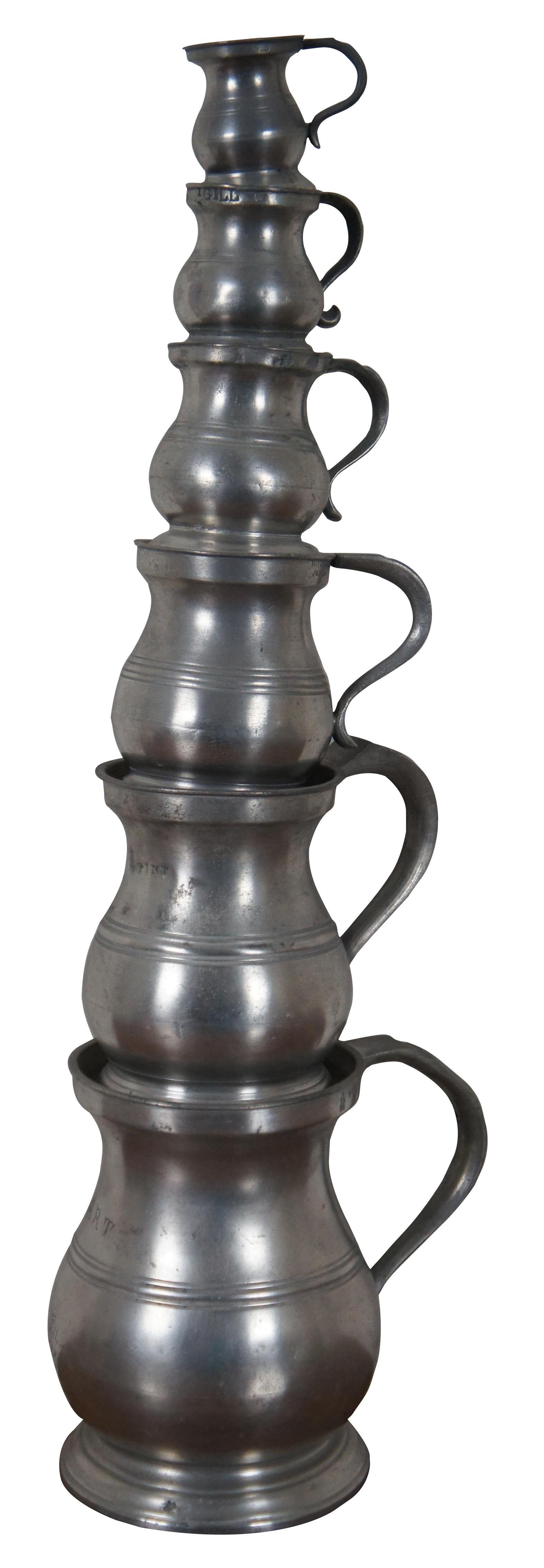 Set of six Victorian / Edwardian English pewter measuring cups, tankards, or mugs featuring a baluster or bellied form with handles and ribbing. The marks found on each mug are described below, numbered from largest to smallest.

#1: Quart –