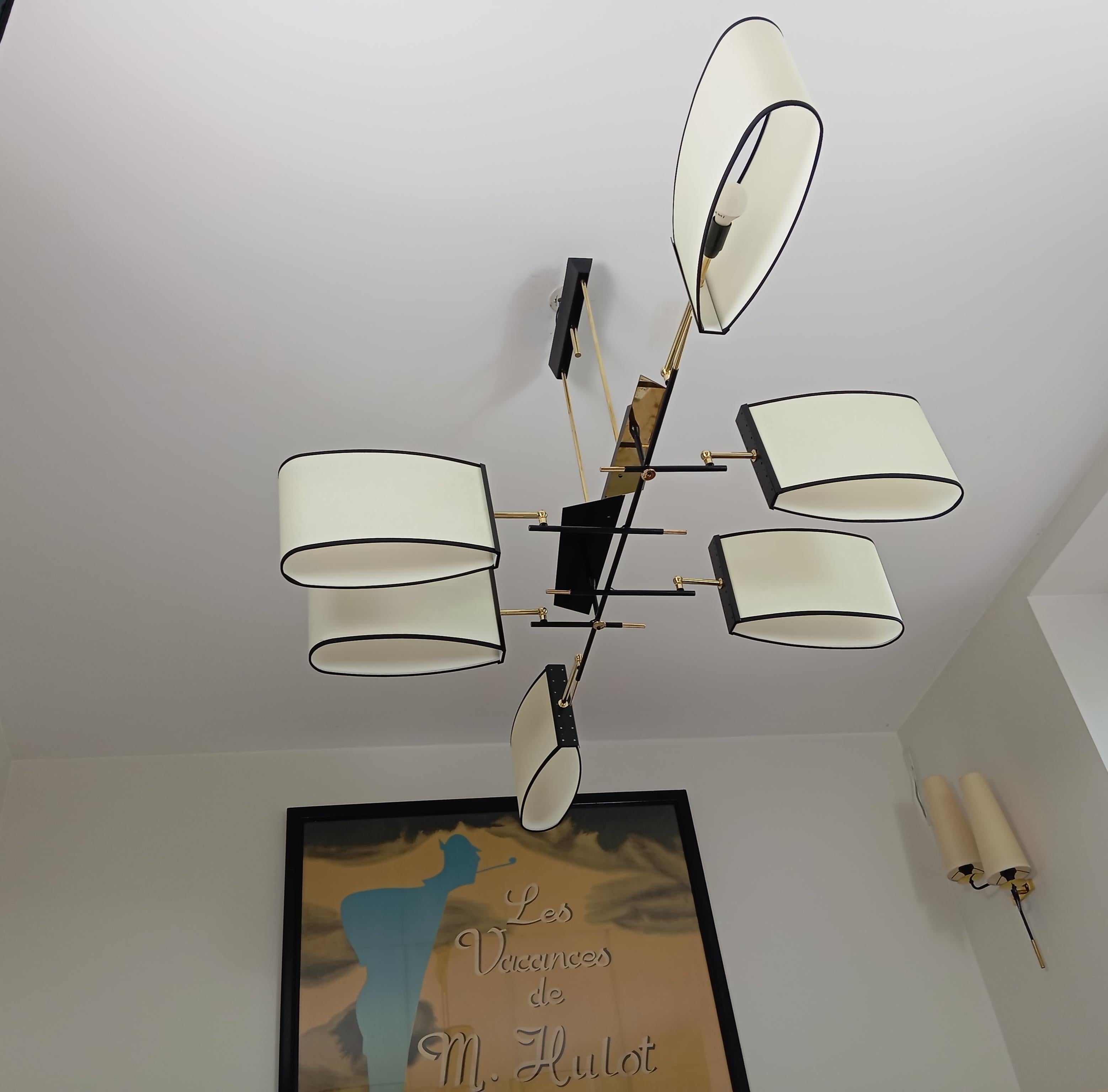 Lampadario in ottone e metallo laccato nero, composto da 6 bracci asimmetrici in metallo e ottone che sostengono paralumi di forma ovale.
Questo lampadario è stato restaurato.
Opera francese della Maison Lunel del 1950 circa.
Condizioni perfette.