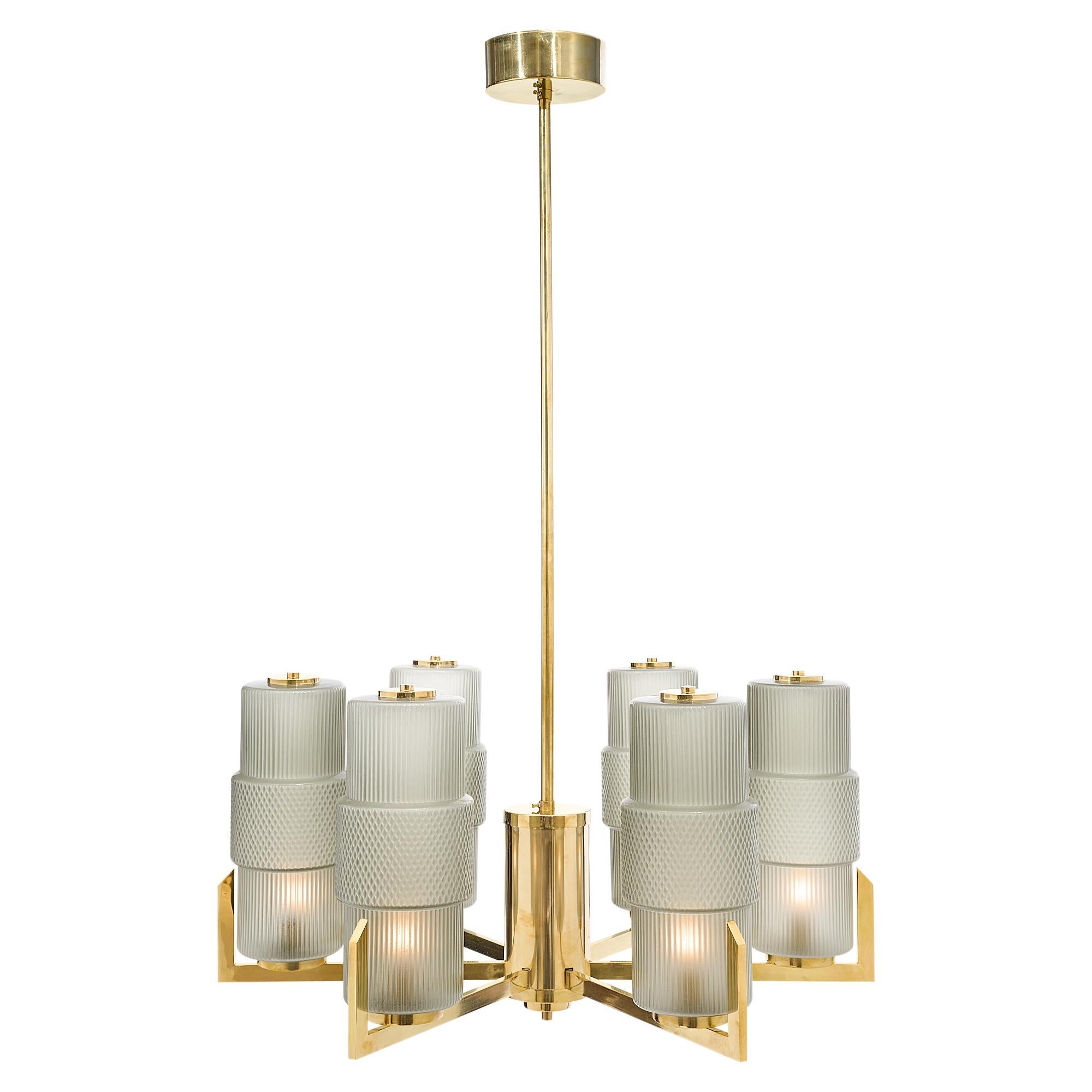Spectacular brass and glass modernist chandeliers with a 6 branch solid brass structures and textured hand blown Murano glass components. A boldly modern chandelier with a very noble neoclassical feel about it, one of our favorites. The price is for