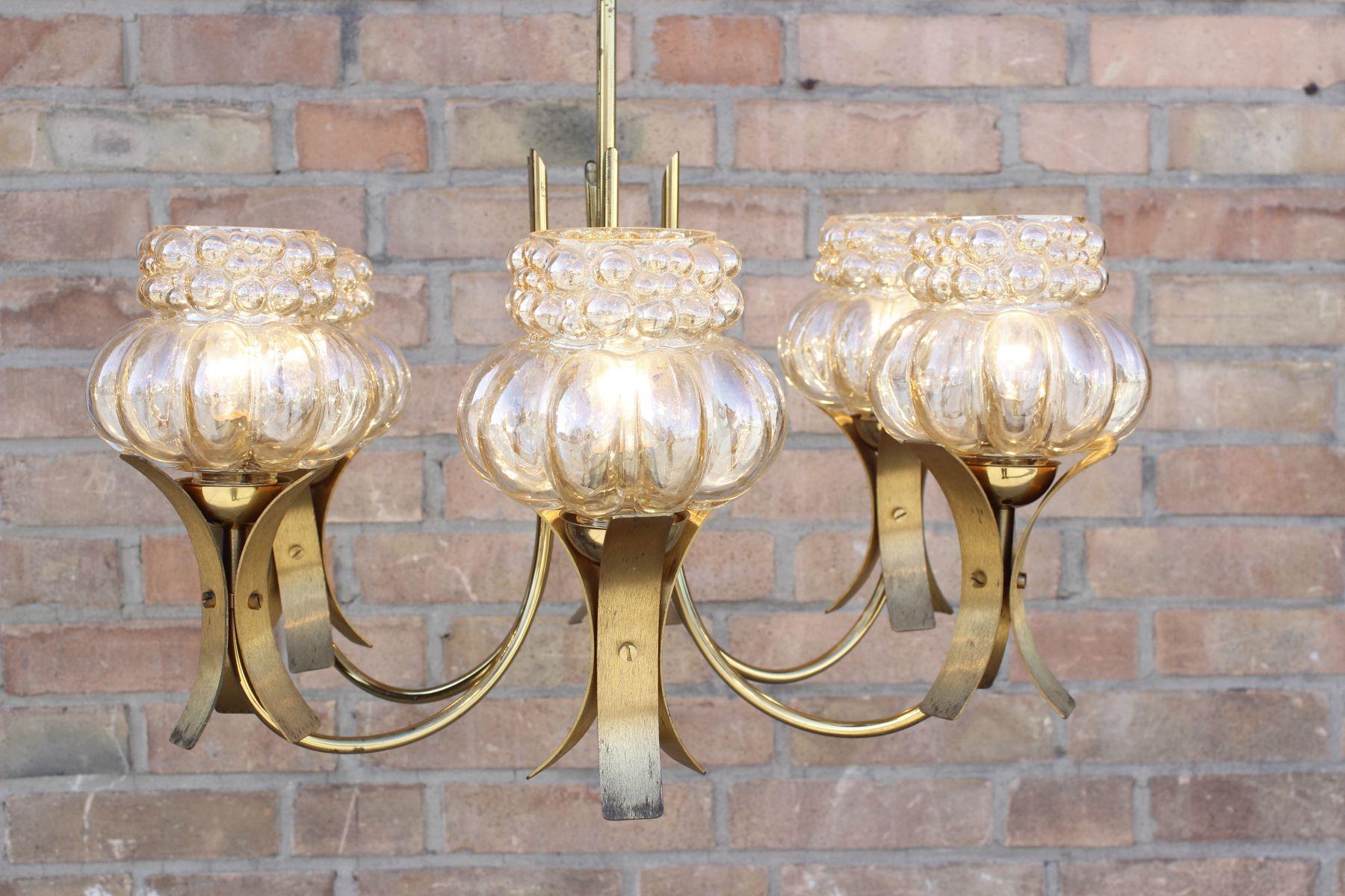 6 Arms chandelier in brass and molded glass, the glass shades are very reminescent of the Bubble series designed by Helena Tynell for Limburg, with a golden tint to them. 

The chandelier is in great condition and great working order, there is no