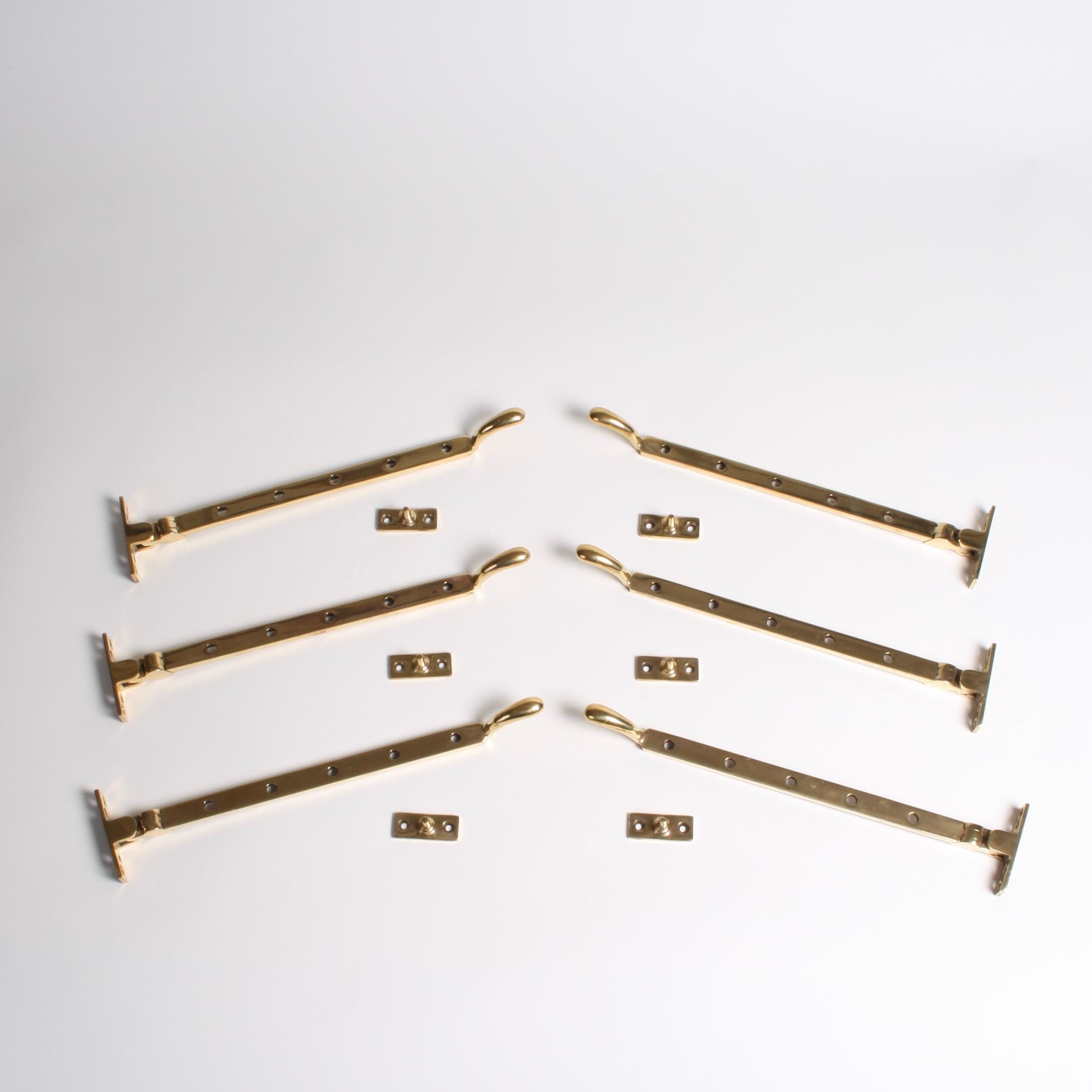 A run of six Art Deco brass casement widow stays each with a matching pins.

Each stay has 5 holes for adjustment of the angle of the window.

The back of each stay is marked W R.

Length of each stay: 32 cm.

4 extra pins included with this