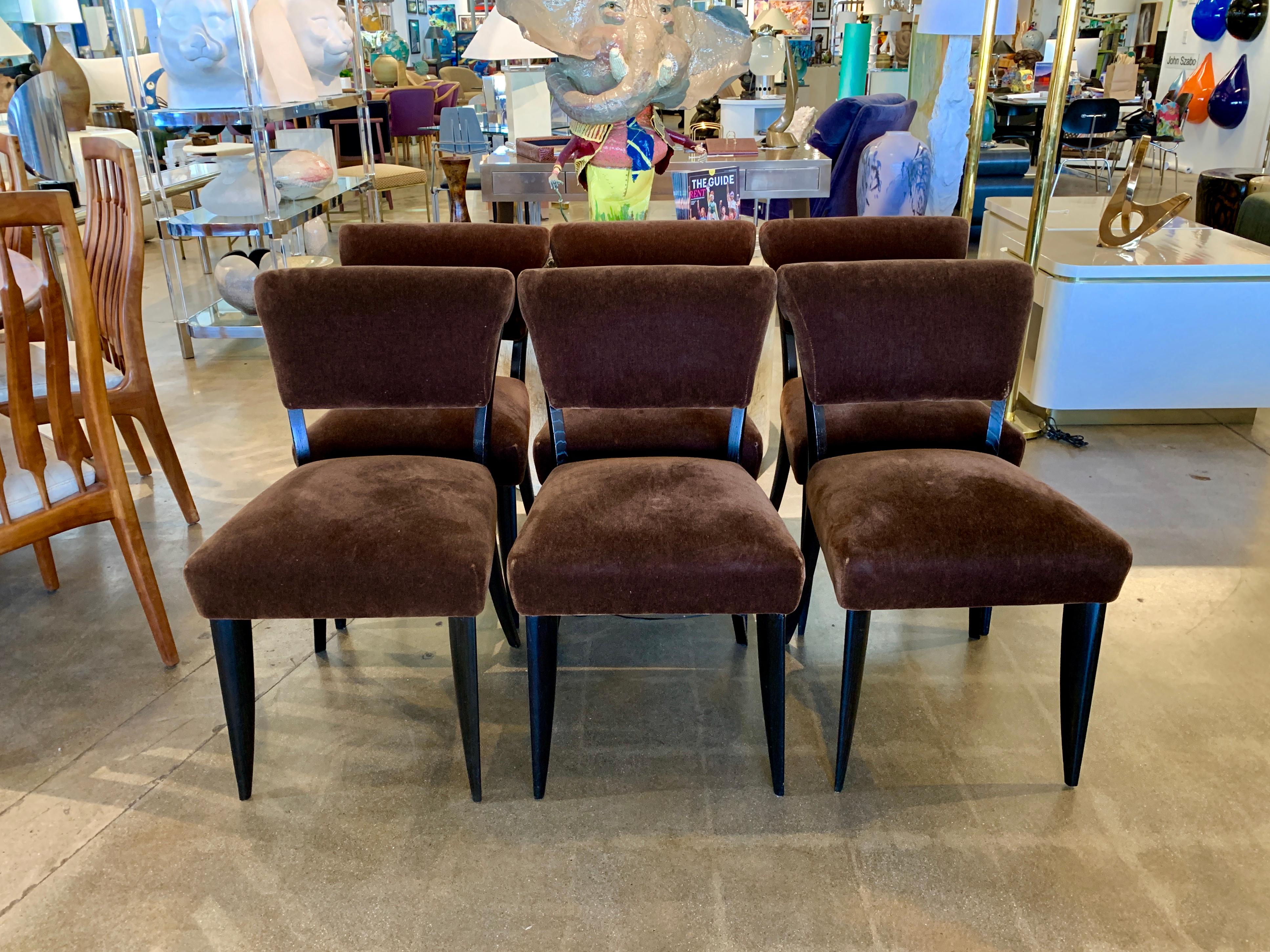 A set of 6 Art Deco dining chairs made of stained oak, handmade in the style of Emile Jacques Ruhlmann. These chairs have an older reupholstery done in dark brown Mohair. We removed one back to illustrate the construction and as can be seen in the